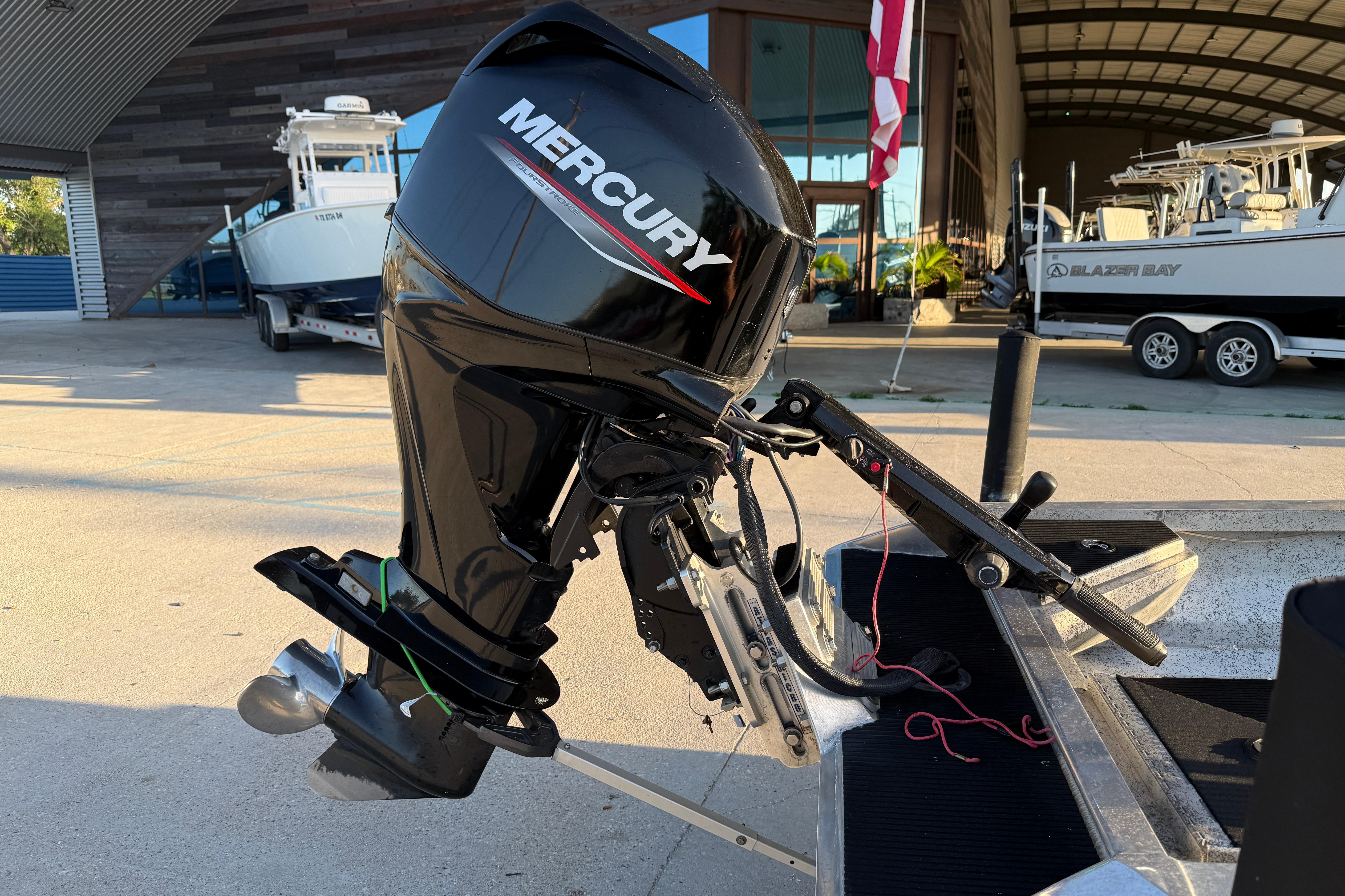 Outboard motor on a 2017 Homemade 1754 boat, parked near a marina.