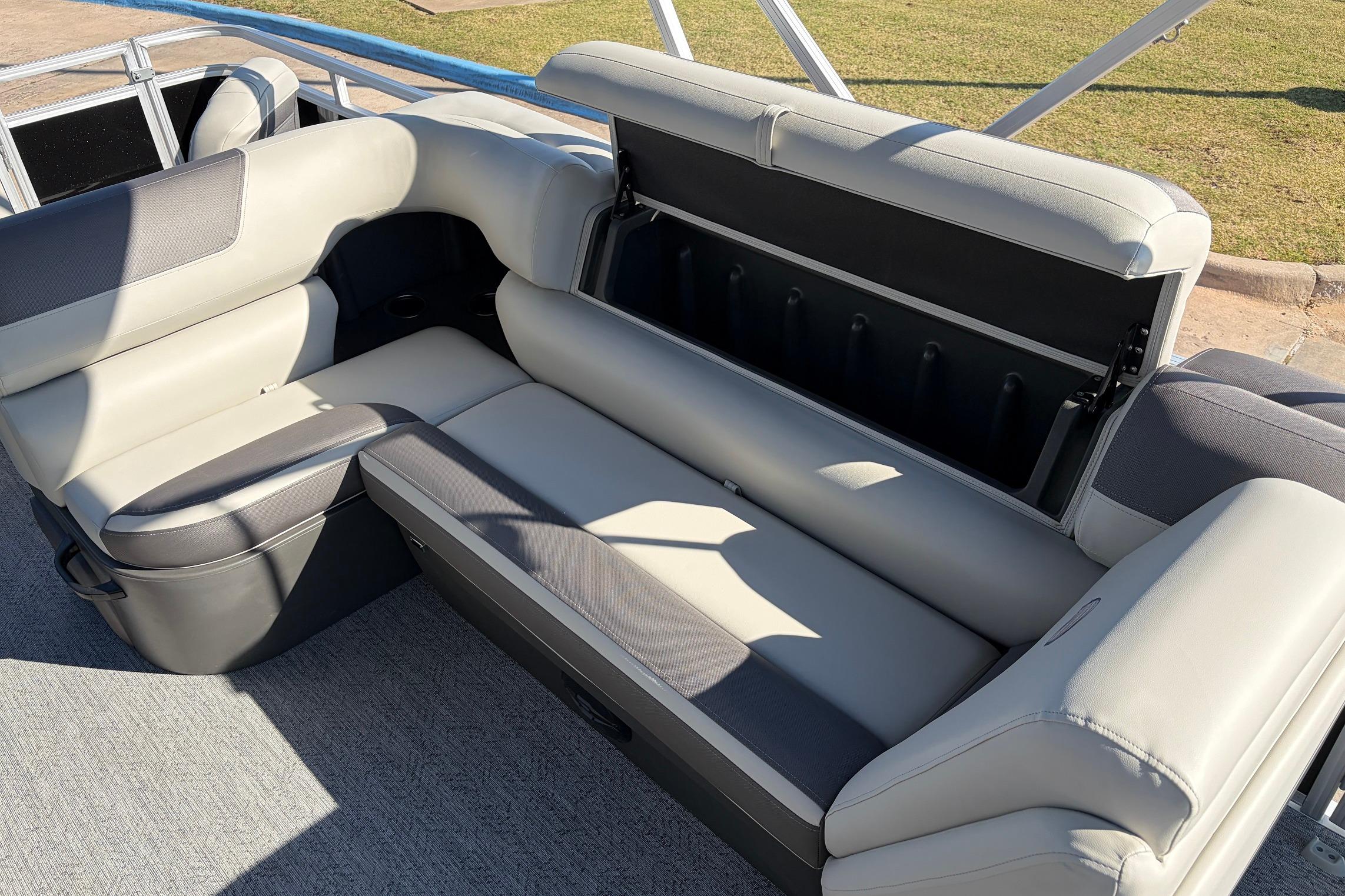 2026 Sun Tracker Fishin' Barge 22 XP3 interior seating with storage compartment open.