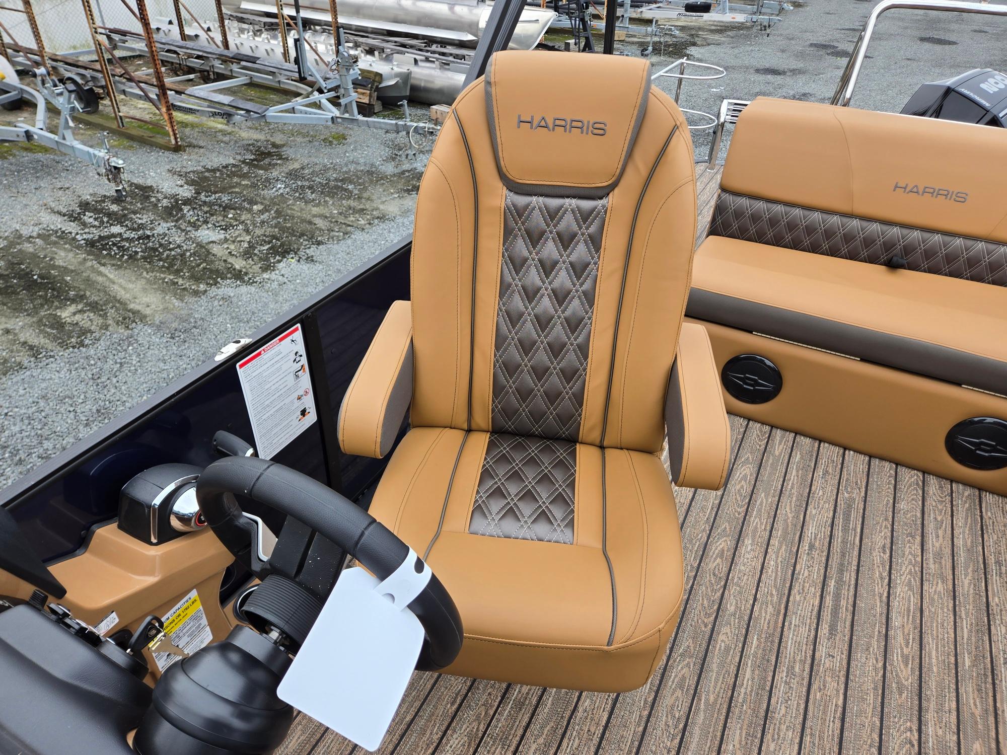2026 Harris Cruiser 210 boat interior with tan and gray seating, steering wheel, and controls.