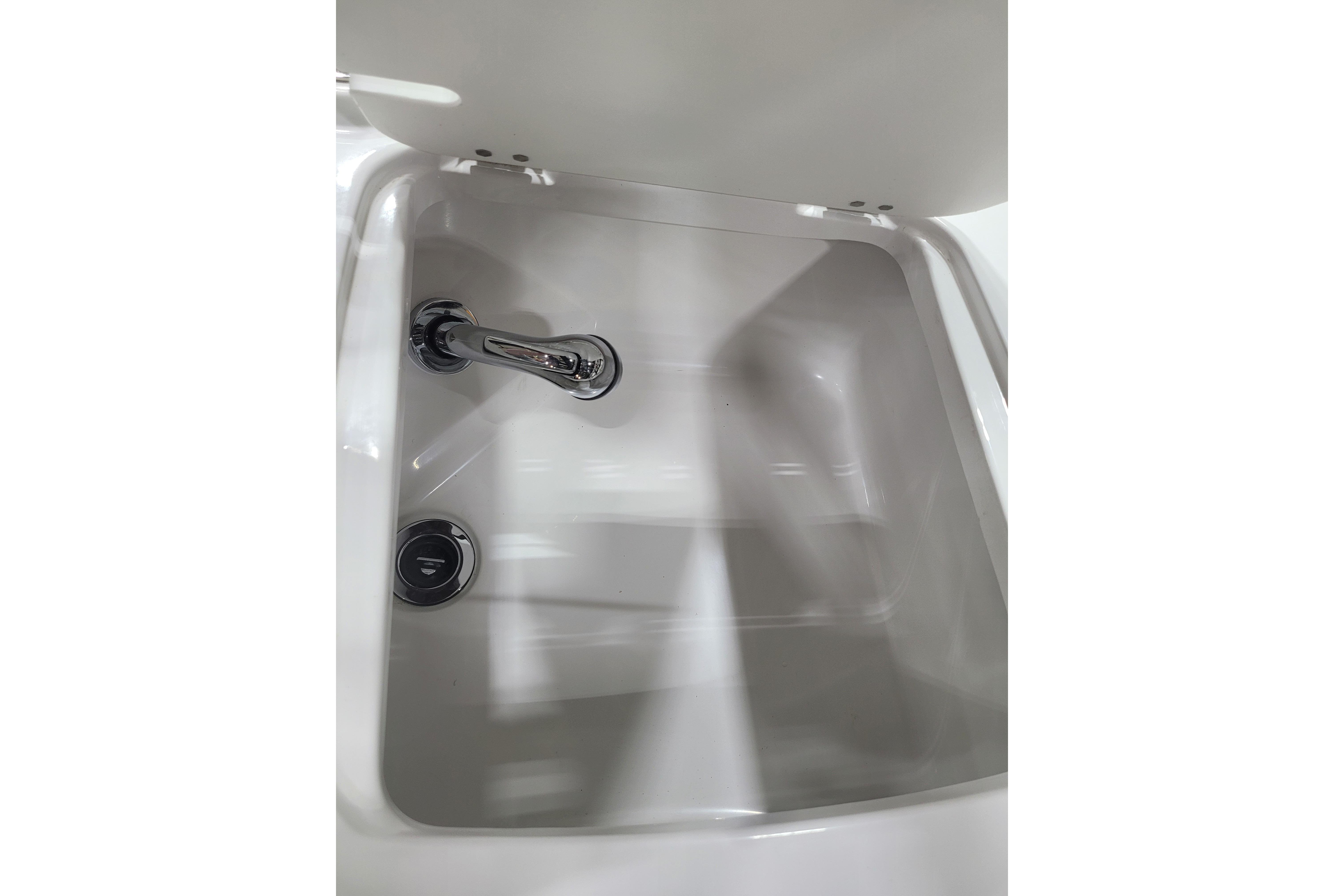 Storage compartment with chrome faucet in 2026 Tahoe 2150 boat.
