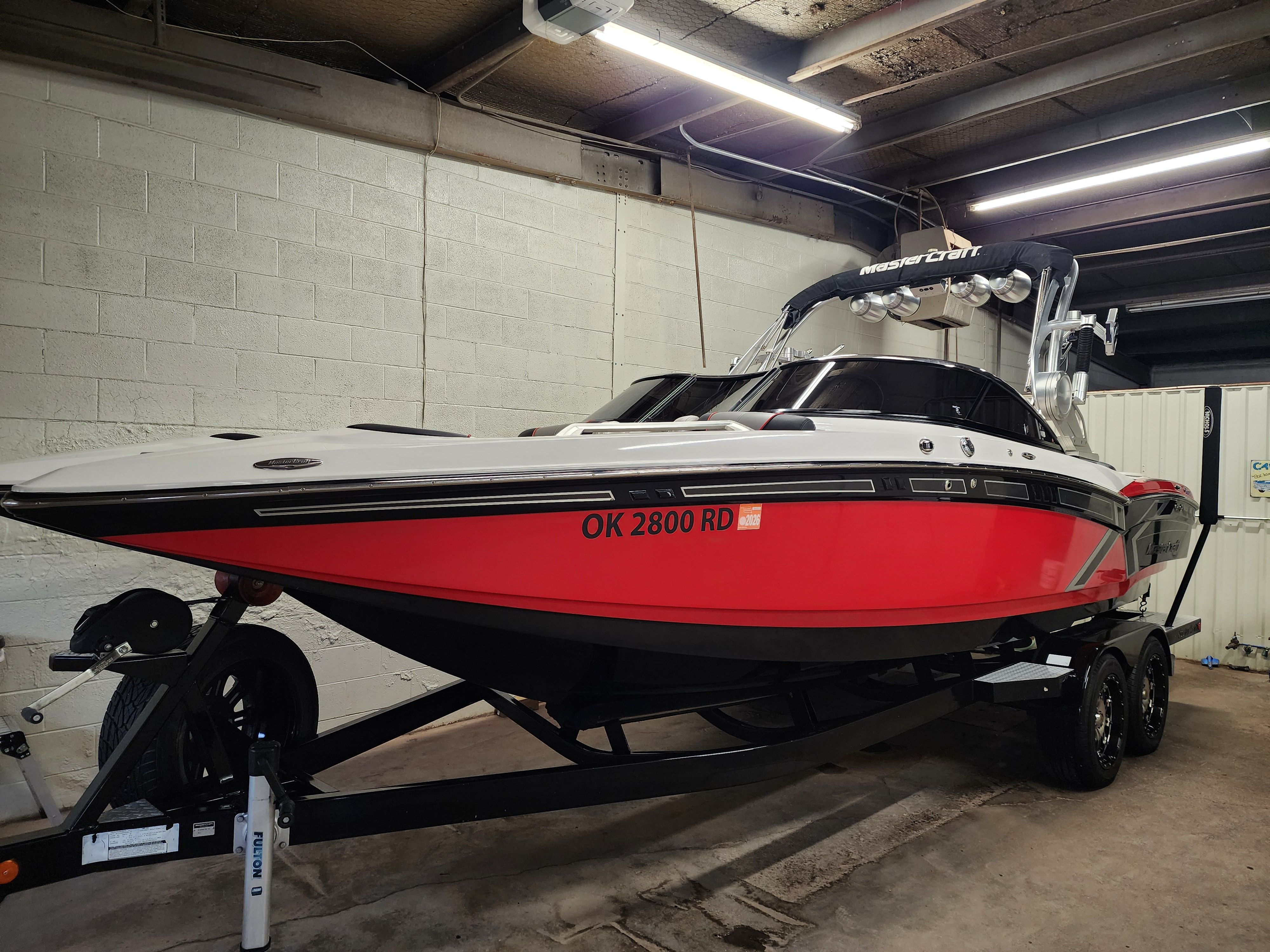 2013 MasterCraft XStar boat in red color inside a garage.