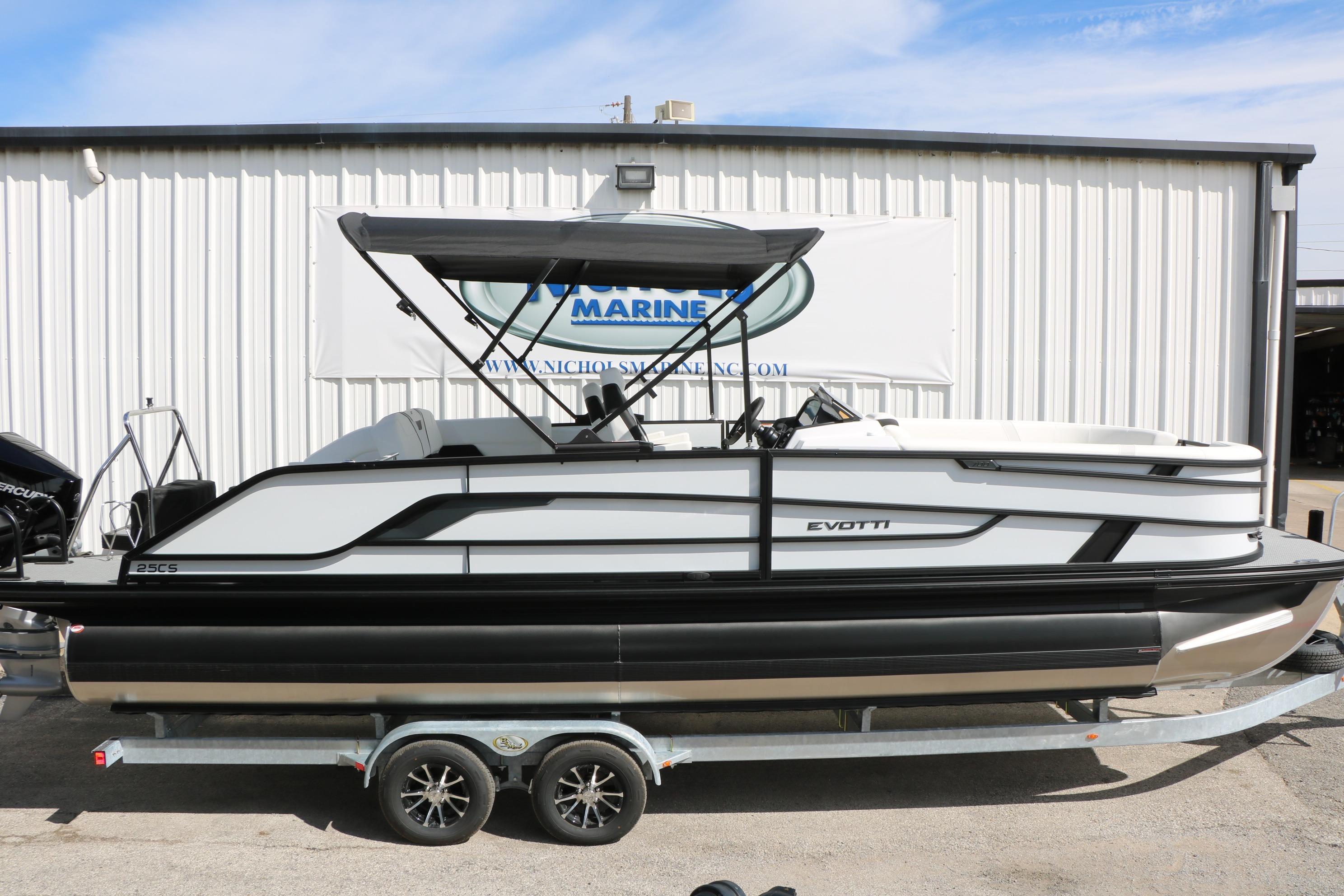 2026 Evotti 725 CS Tri-Toon boat on trailer, parked outside a marine facility.
