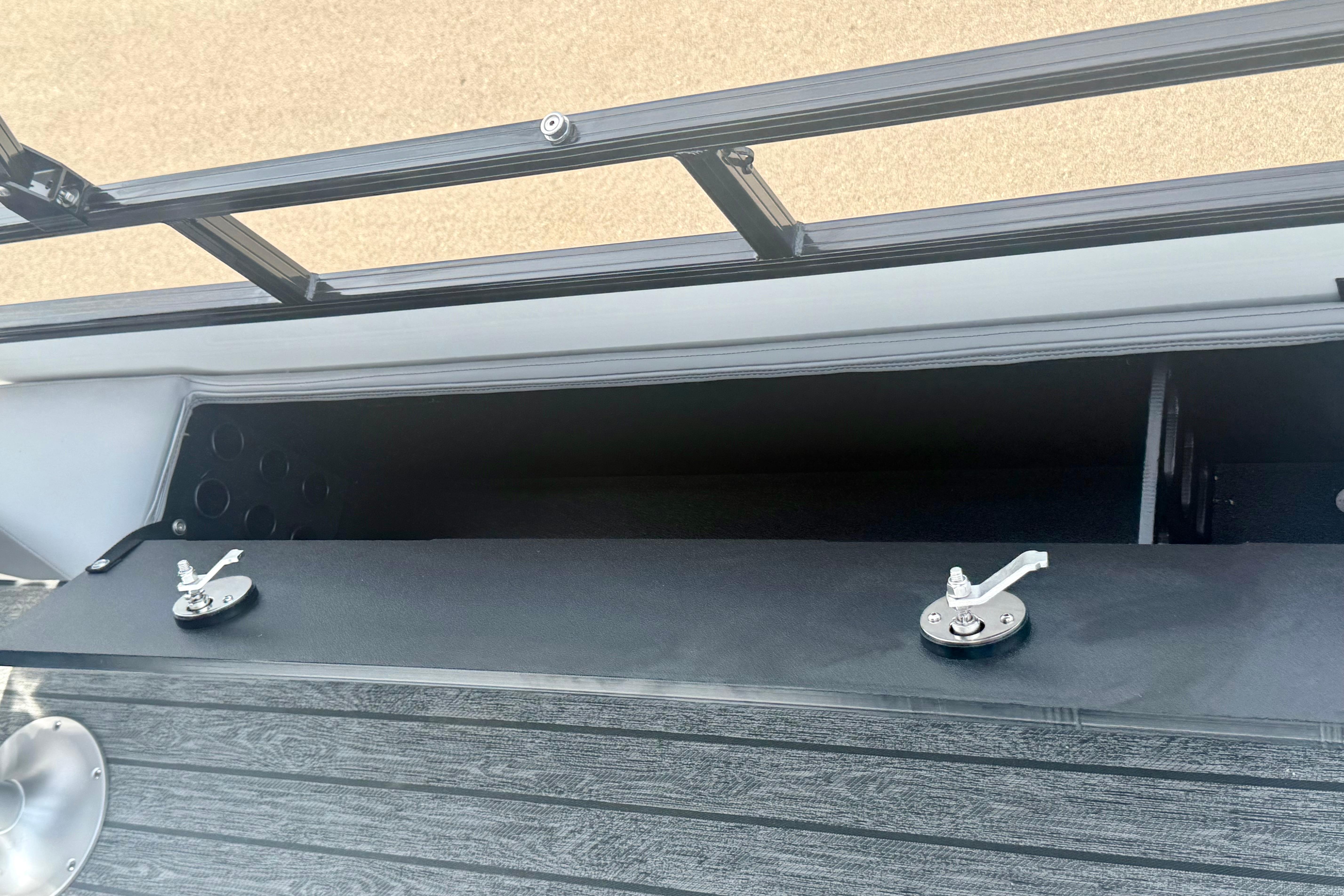 Open storage compartment on 2026 Ranger 223FC boat with secure latches.