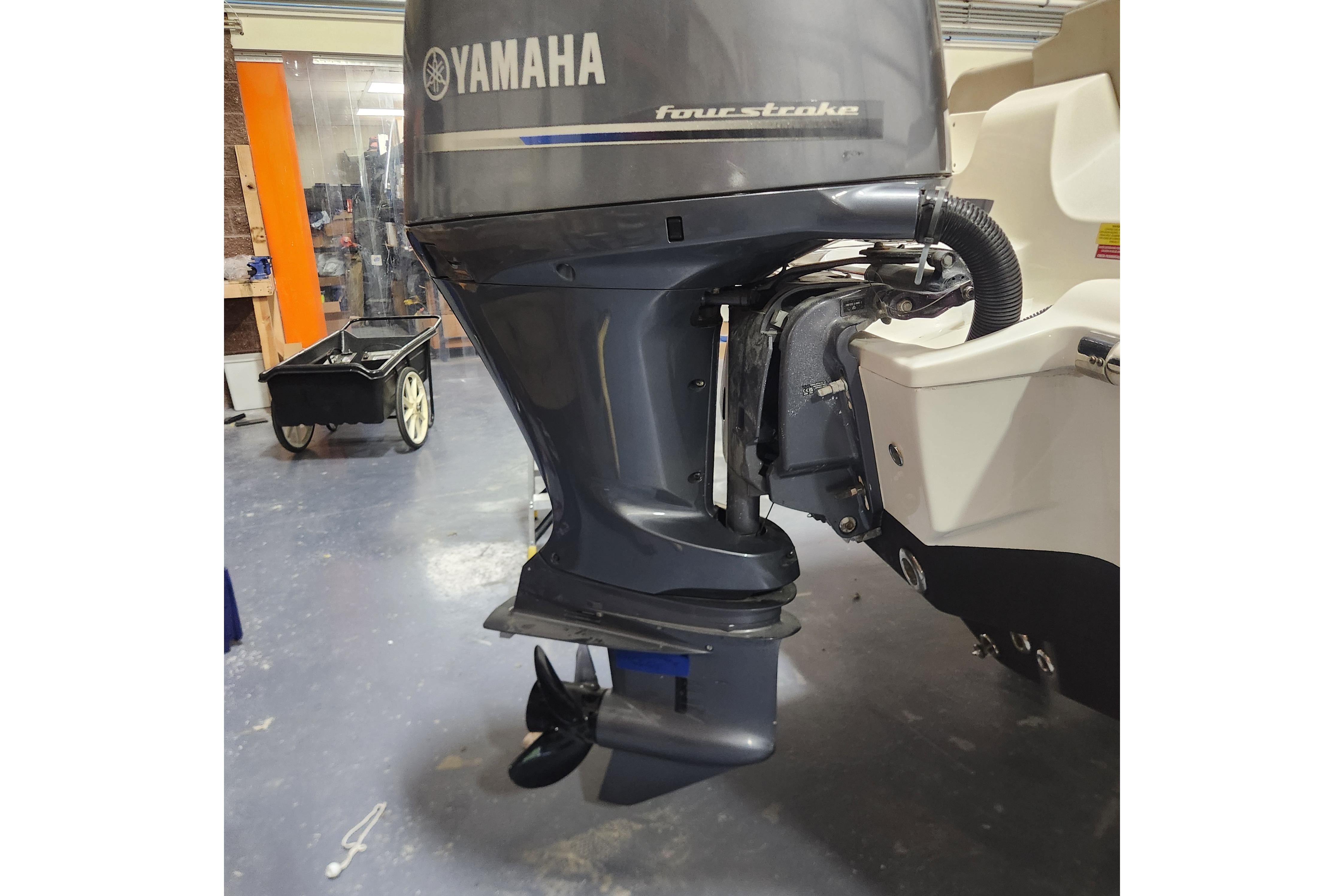 2023 Key West 219 FS boat with Yamaha four-stroke outboard motor in a garage.