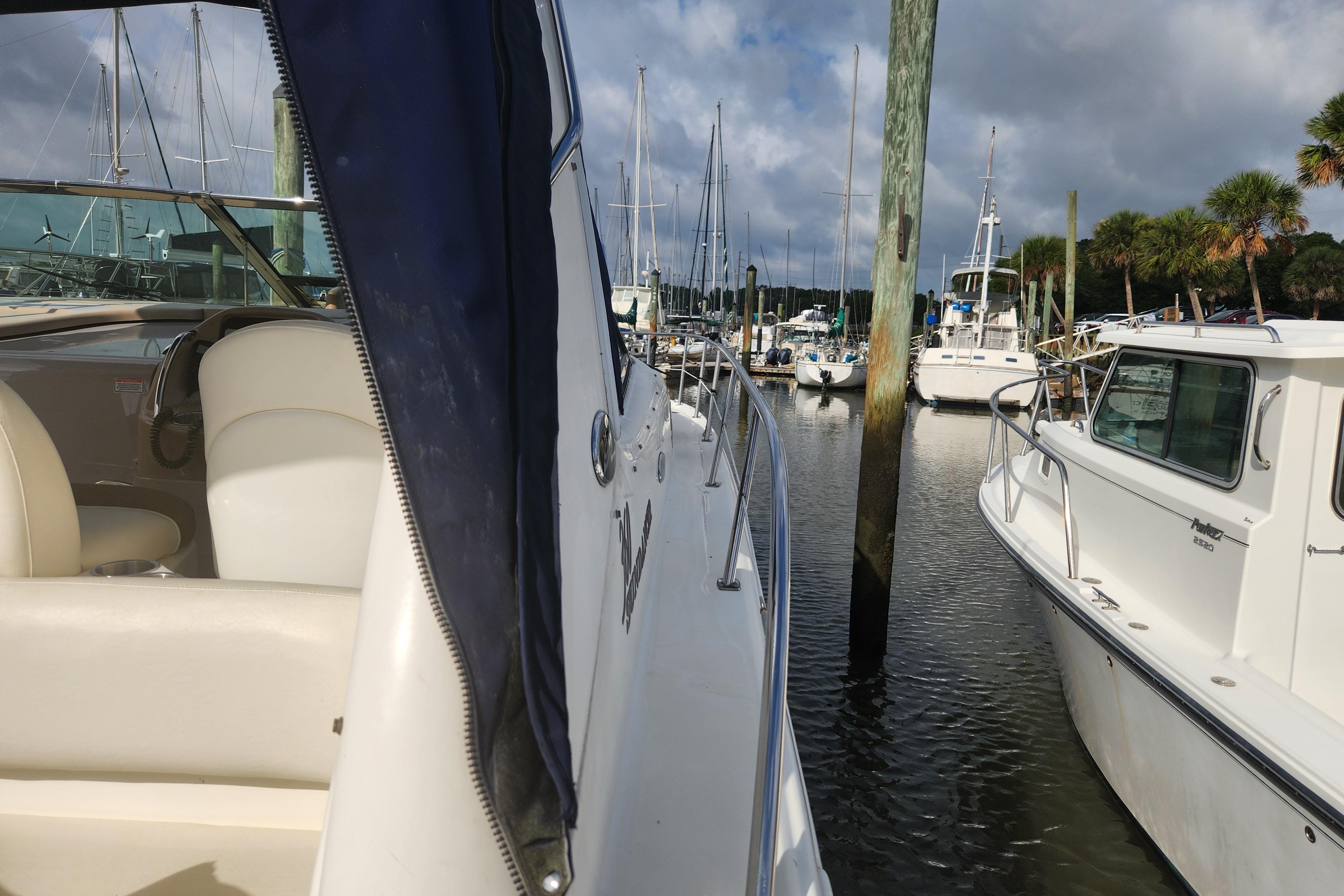 2003 Sea Ray 360 Sundancer docked at marina, surrounded by other boats under cloudy sky.