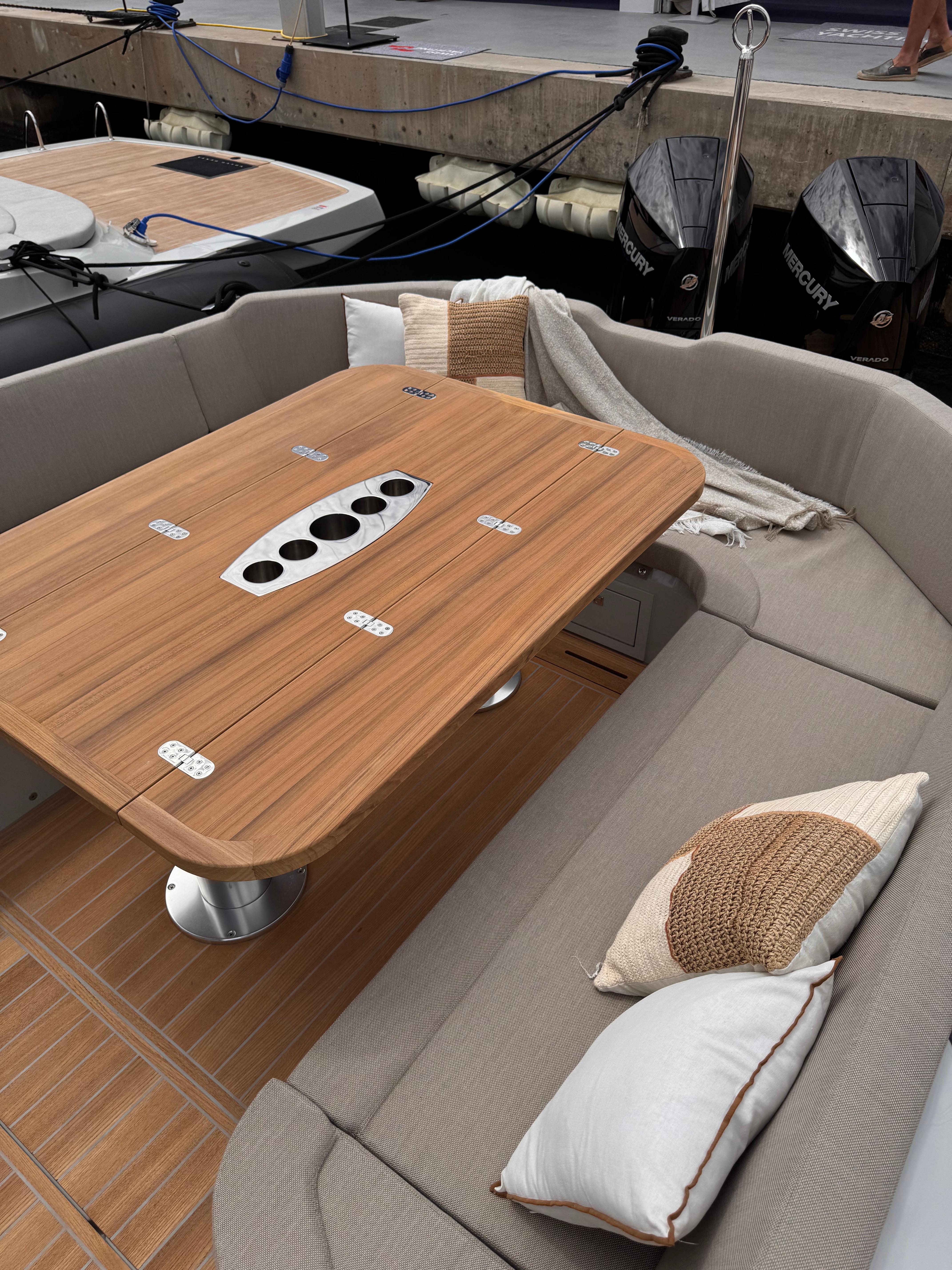 2025 SACS Strider 11 OB Sundeck with elegant seating and wooden table.