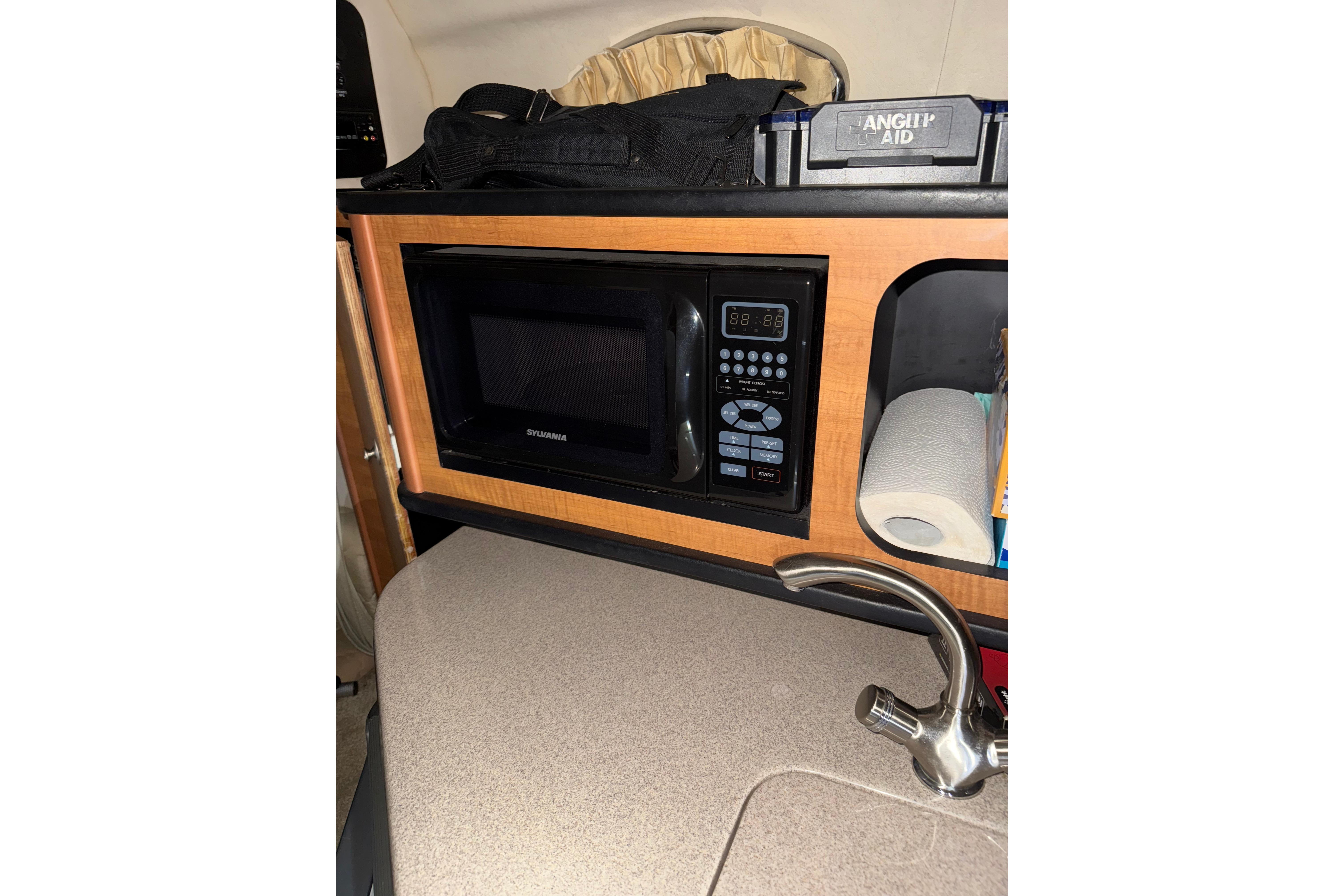 2006 Sea Ray 260 Sundancer interior with microwave, sink, and storage shelf.
