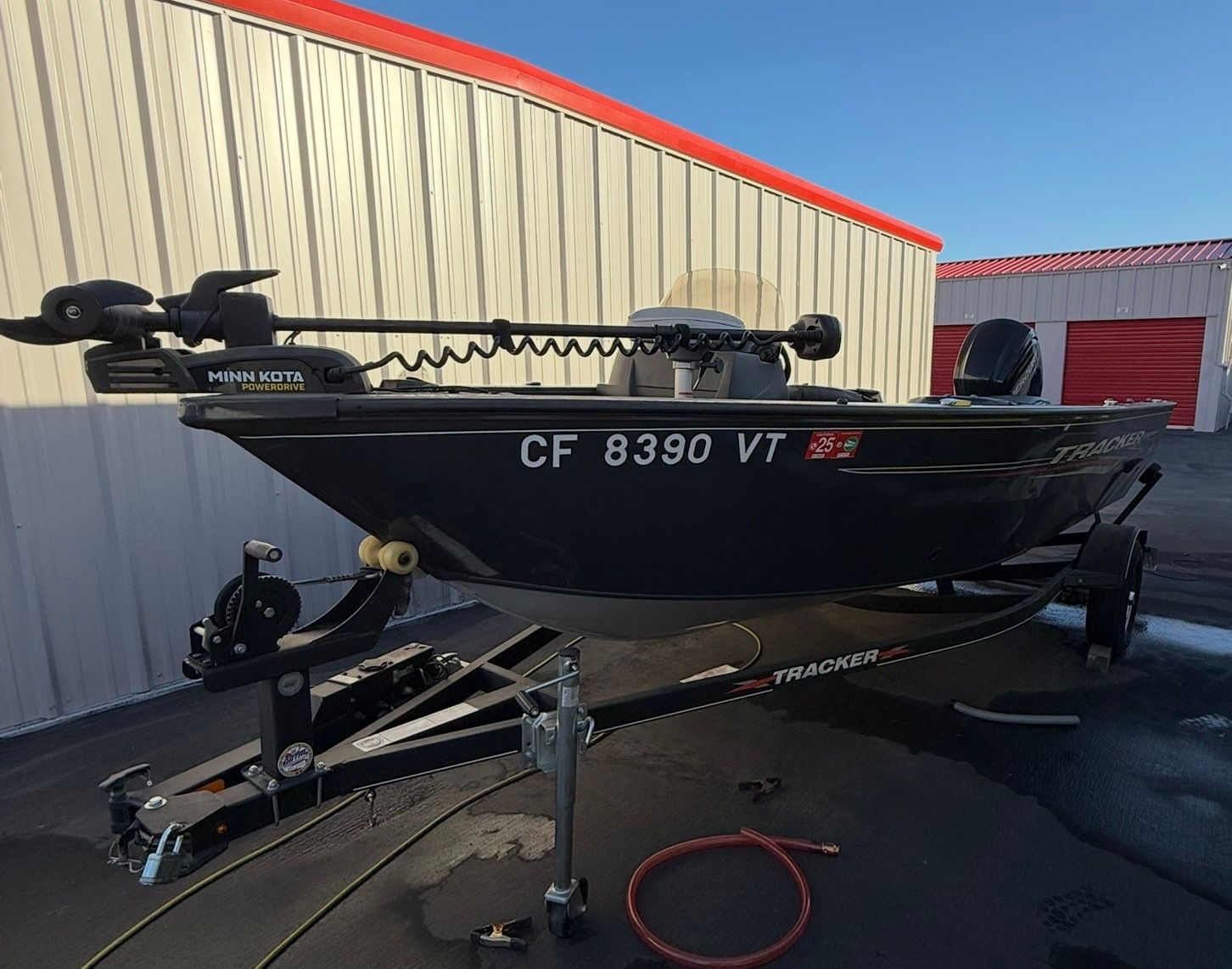 A 2021 Bass Tracker Pro Guide V 16 on a trailer in front of a building.