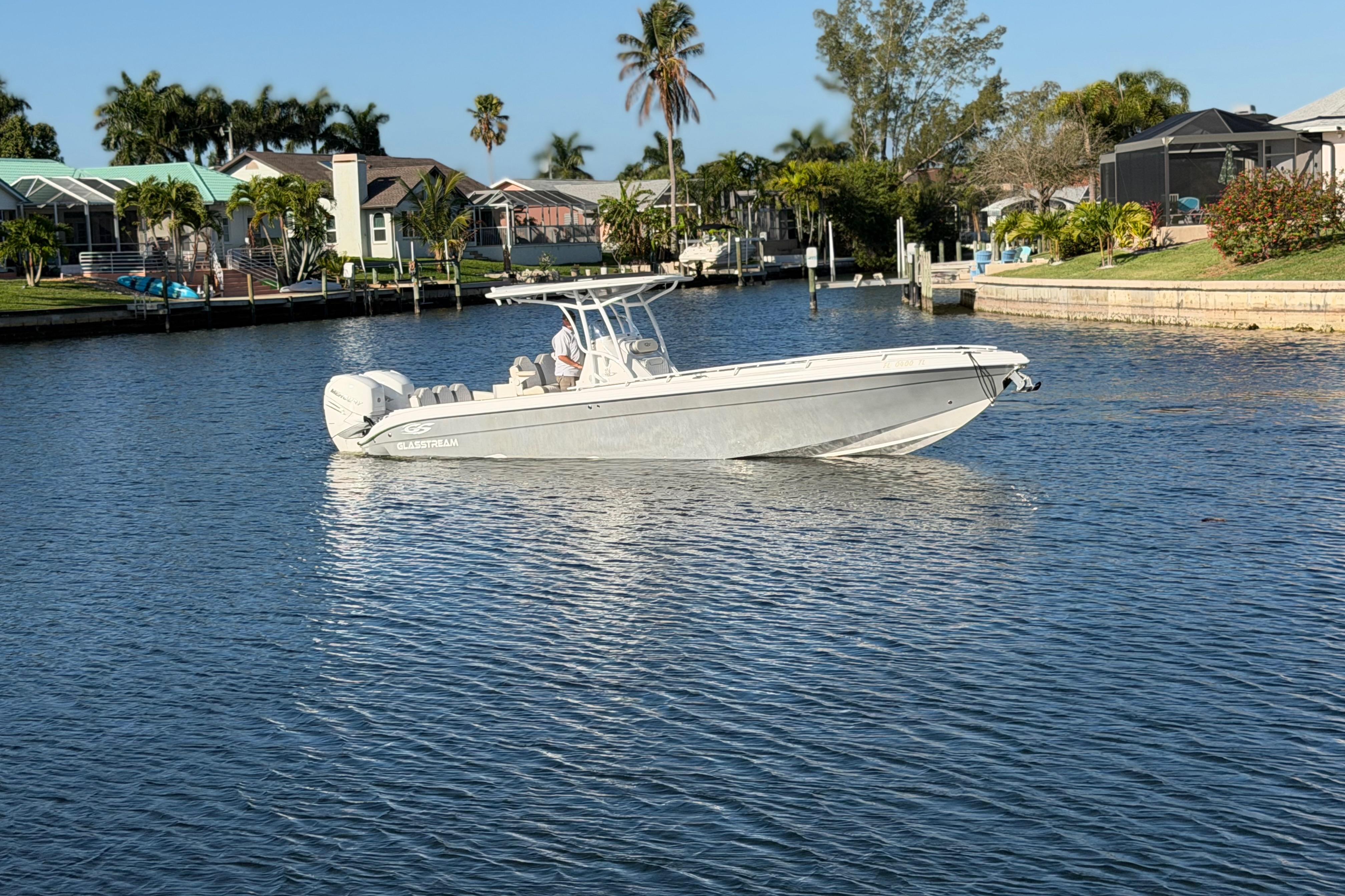 2022 Glasstream 328 Pro-XS boat on a calm waterway, surrounded by lush greenery.