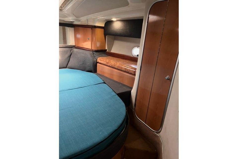 Interior of 1999 Sealine F44 yacht with wood cabinetry and blue seating.