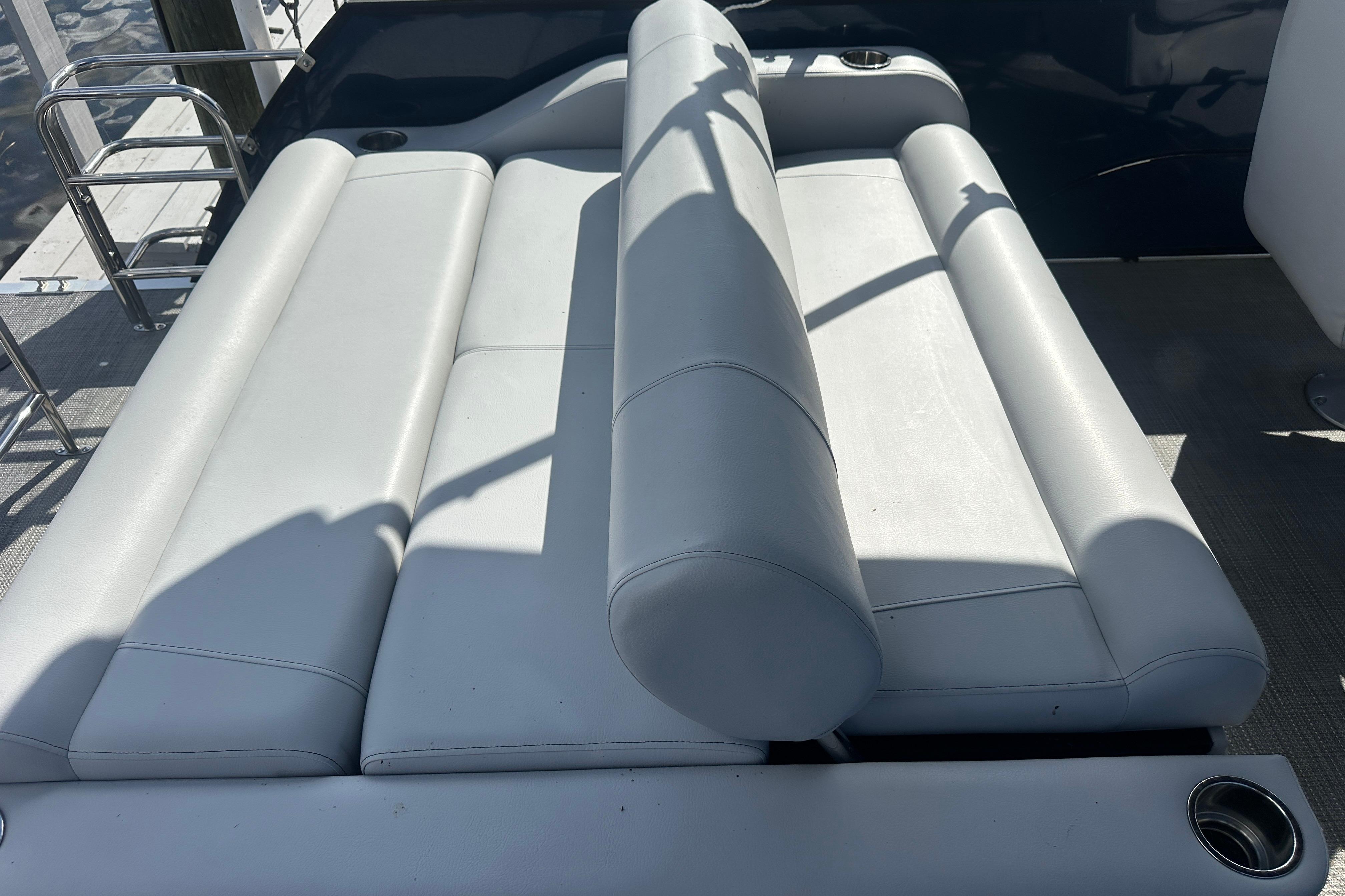 2023 Bentley Pontoons Legacy 243 Swingback seating area with white upholstery and cup holders.