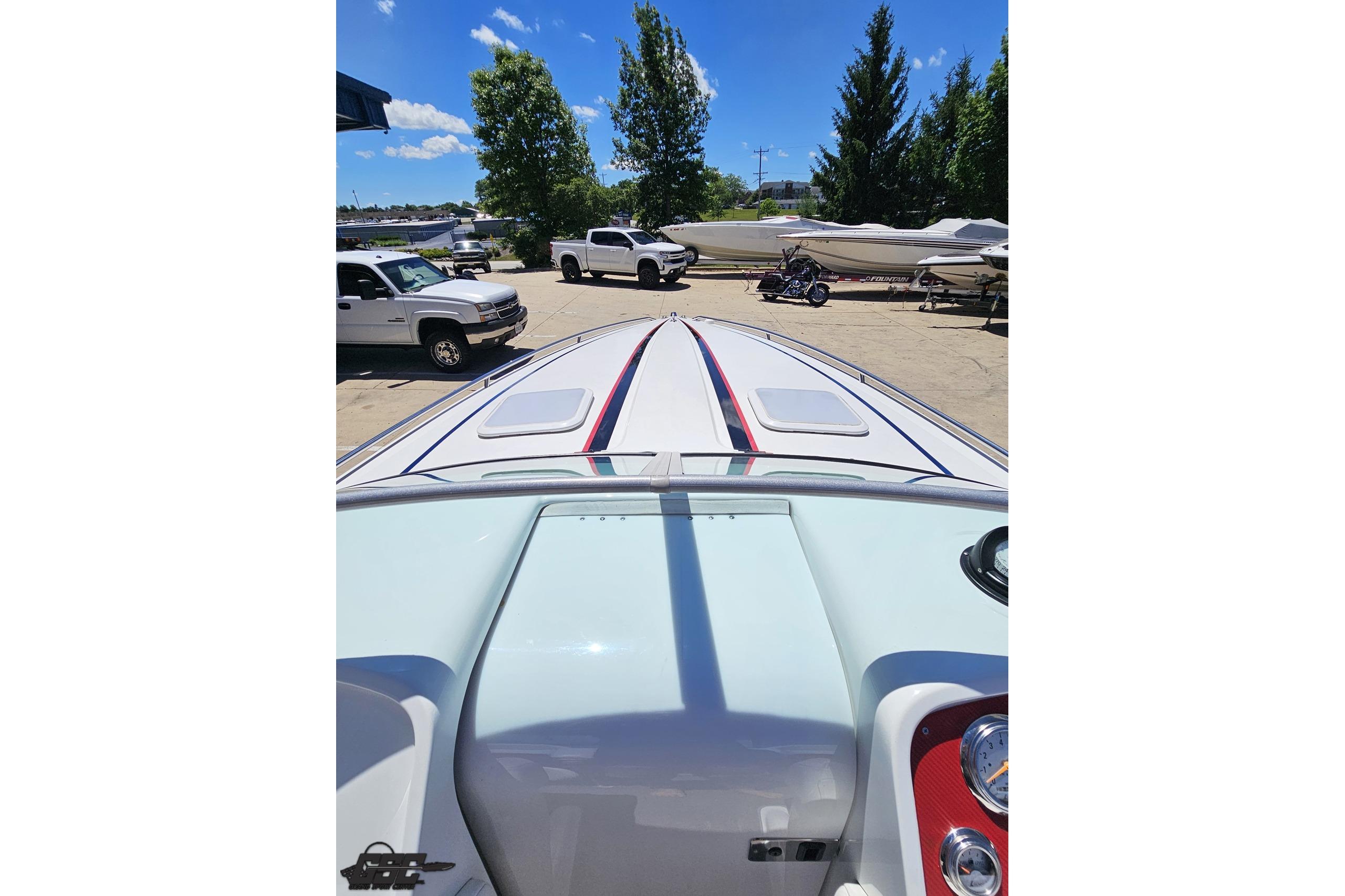 2005 Formula 271 FASTech boat with sleek design, parked outdoors under clear blue sky.