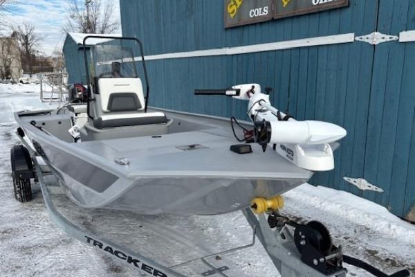 2026 Tracker Bass Tracker Classic CC boat on trailer, parked near blue building.