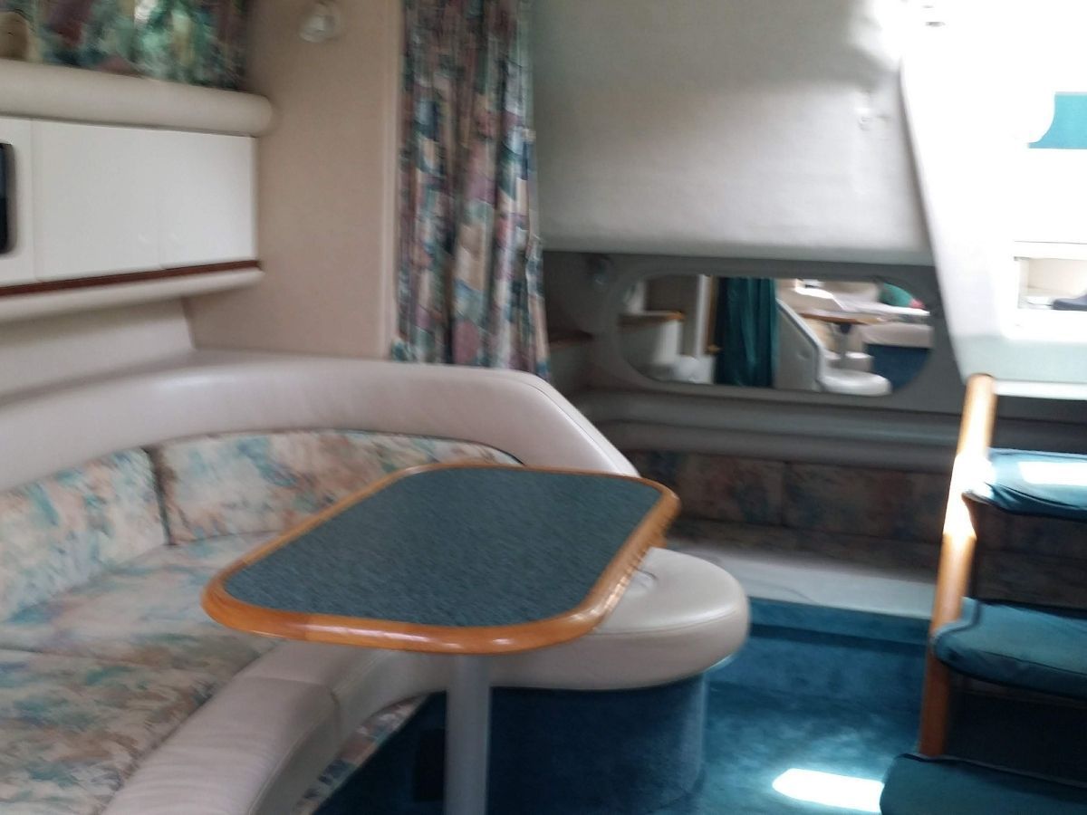 Interior of a 1995 Sea Ray Sundancer 330 with seating area and table.
