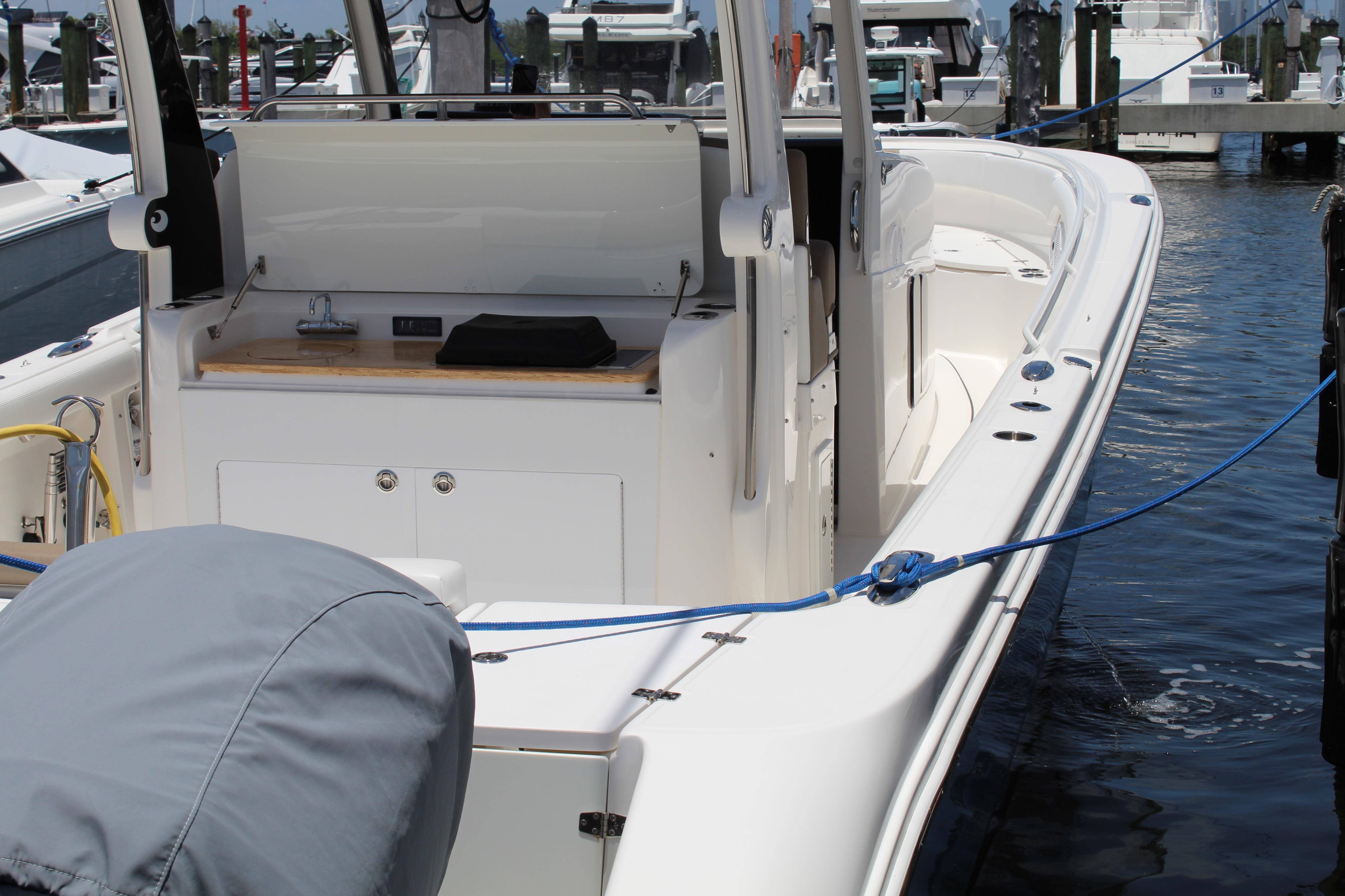 2016 Edgewater 370CC boat docked, showcasing sleek design and spacious deck.