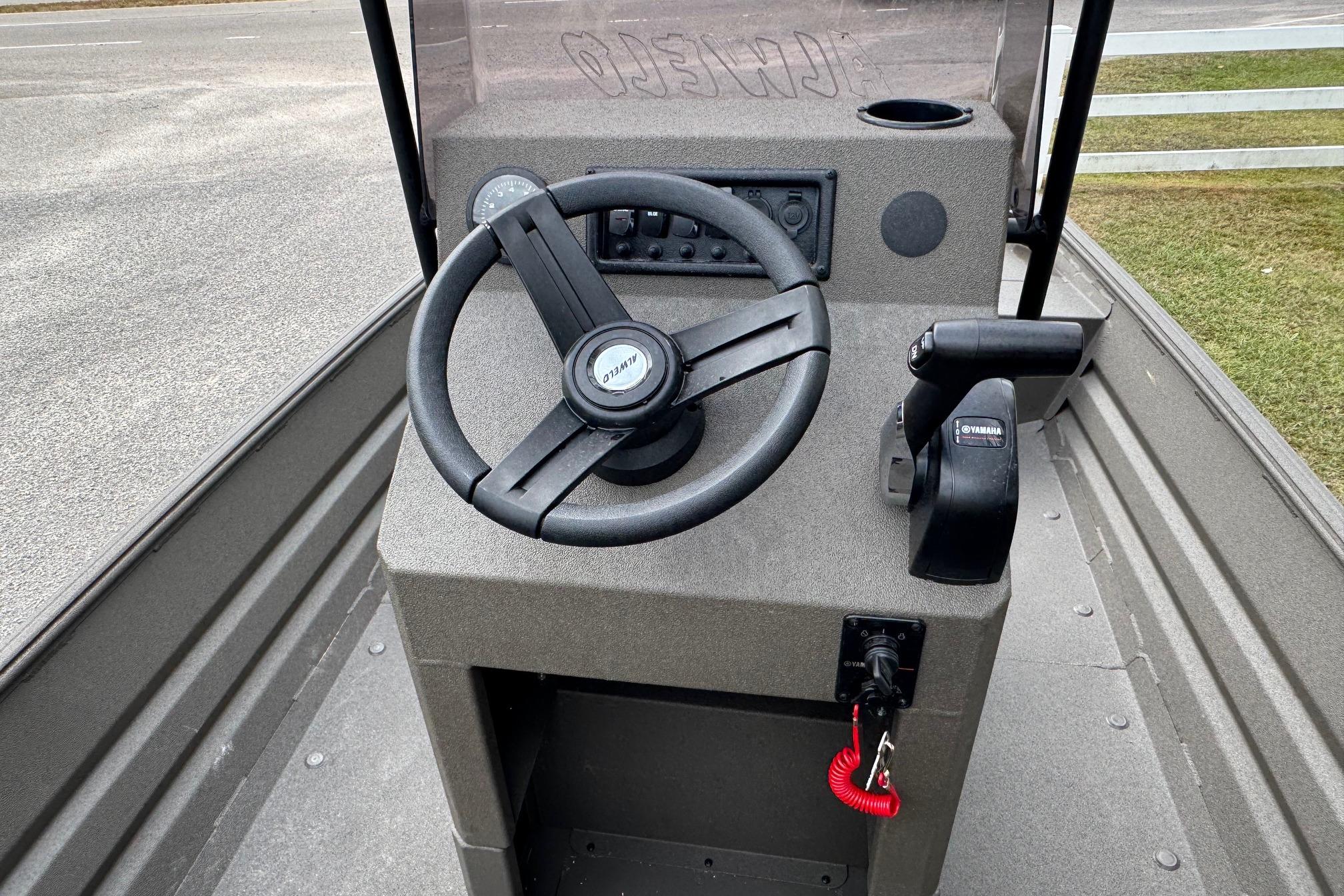 2026 Alweld 1656VV Marsh Console CC boat steering console with controls and cup holder.