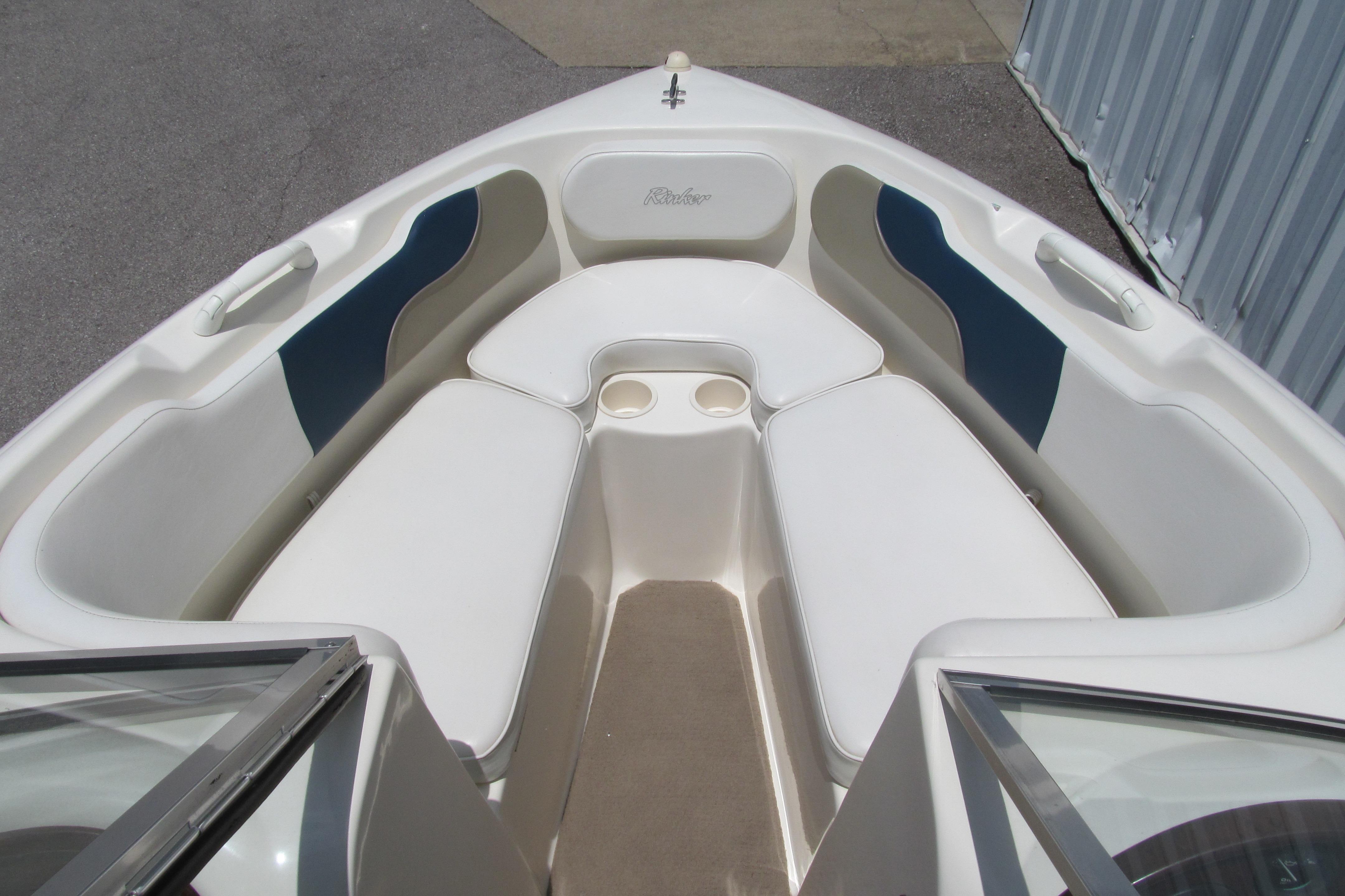 2000 Rinker boat interior with white and blue seating, featuring cup holders.