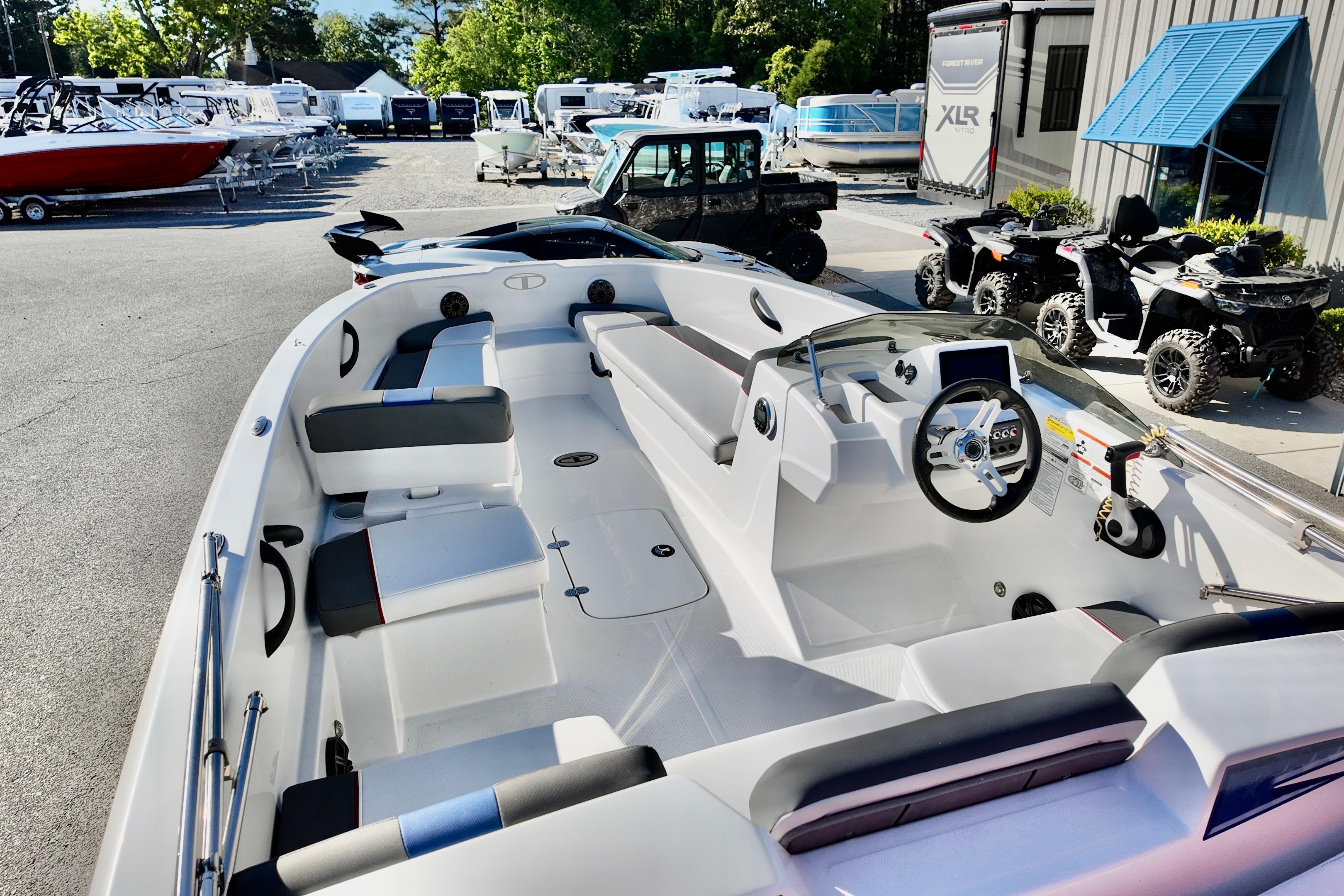 2024 Tahoe T18 boat interior with modern seating and steering, displayed at a dealership.