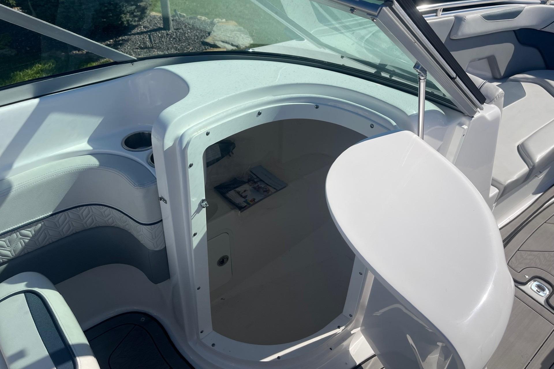 2023 Hurricane SunDeck 2400 OB boat interior with open storage compartment and seating area.