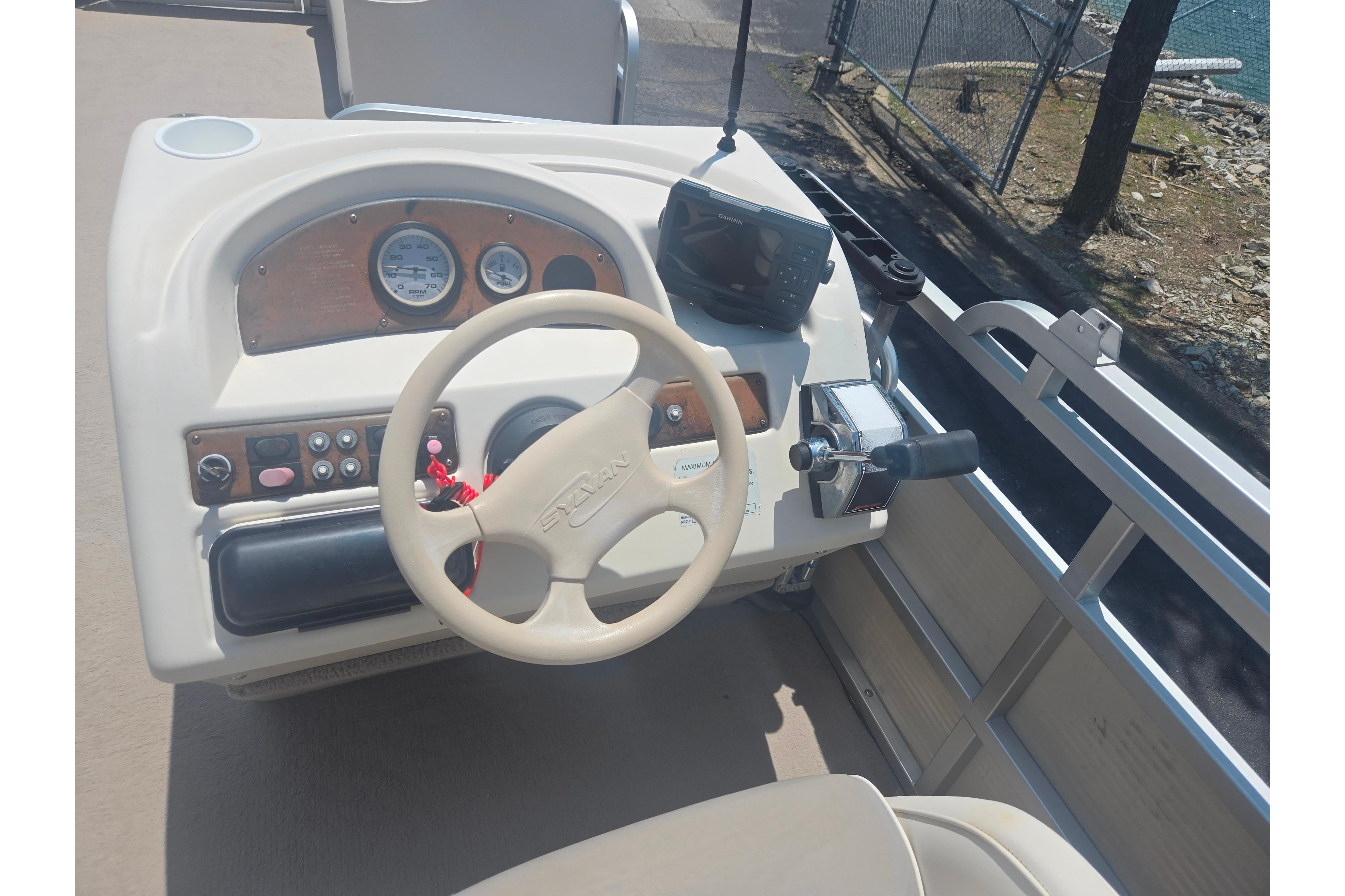 Steering console of a 2000 Sylvan 824 Elite Cruise boat with controls and gauges.