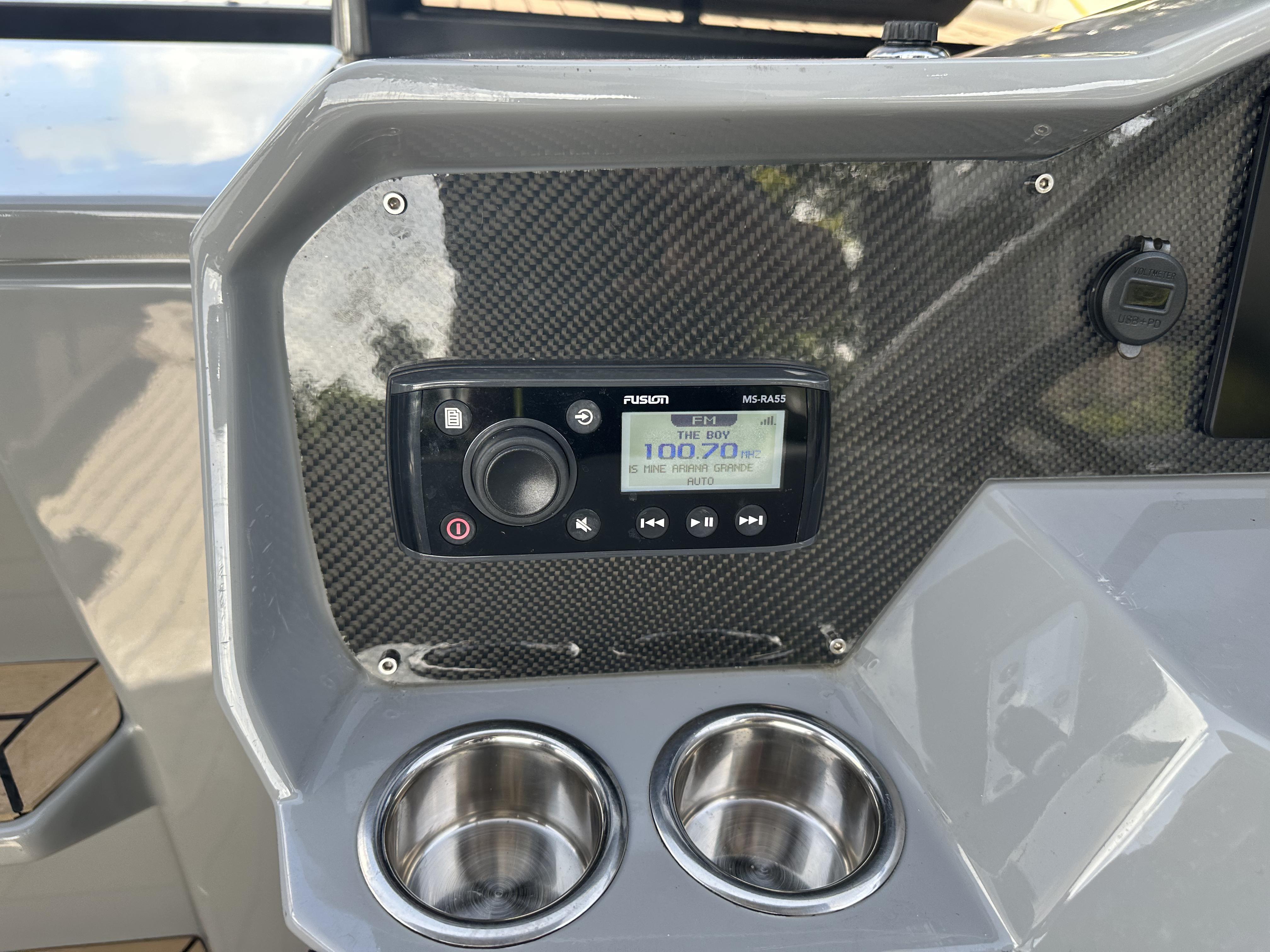 Control panel of 2021 Rand Leisure boat with stereo system and cup holders.