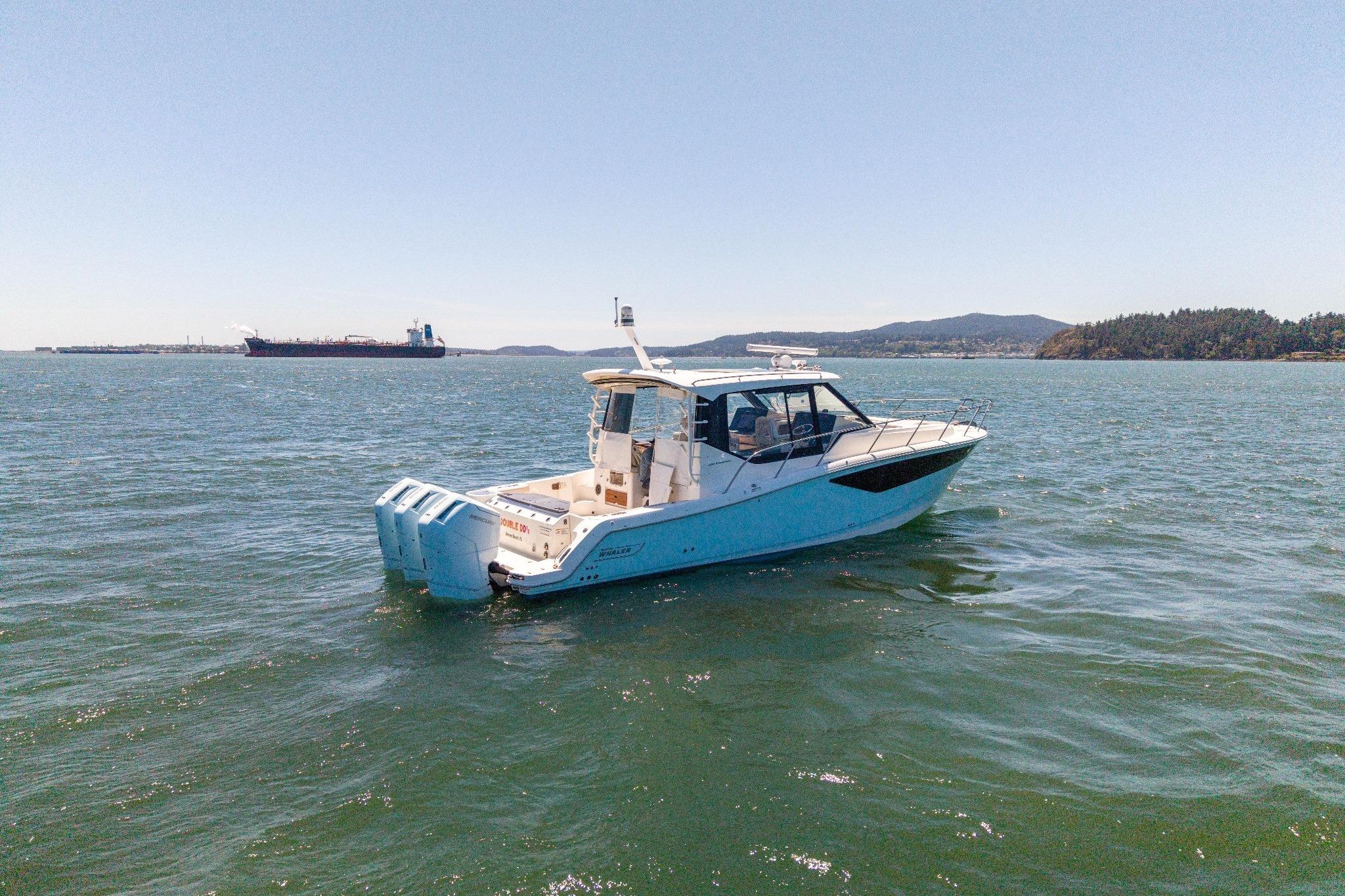 2023 Boston Whaler 405 Conquest boat cruising on open water with scenic background.