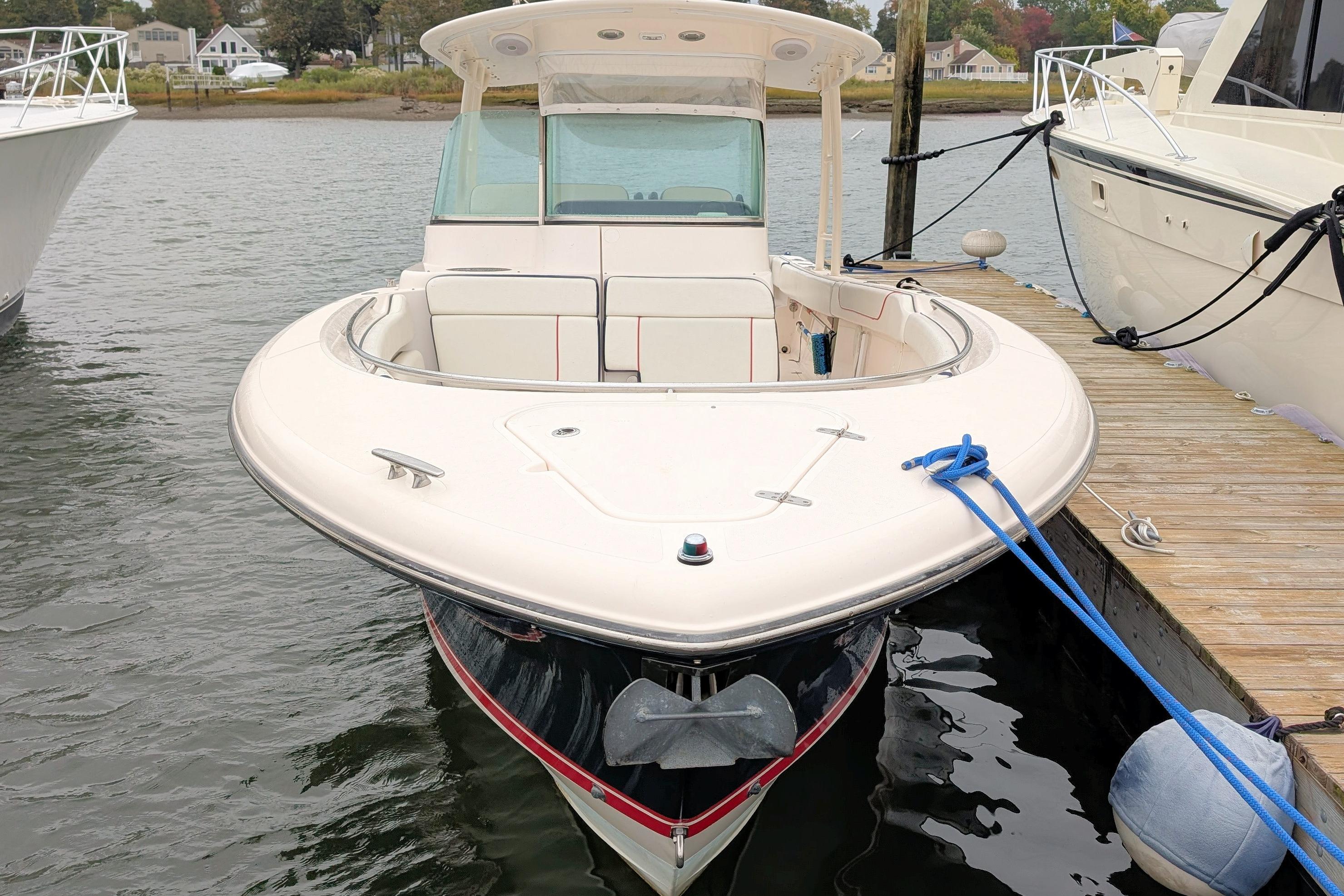 2013 Pursuit ST 310 Sport boat docked at marina, front view.
