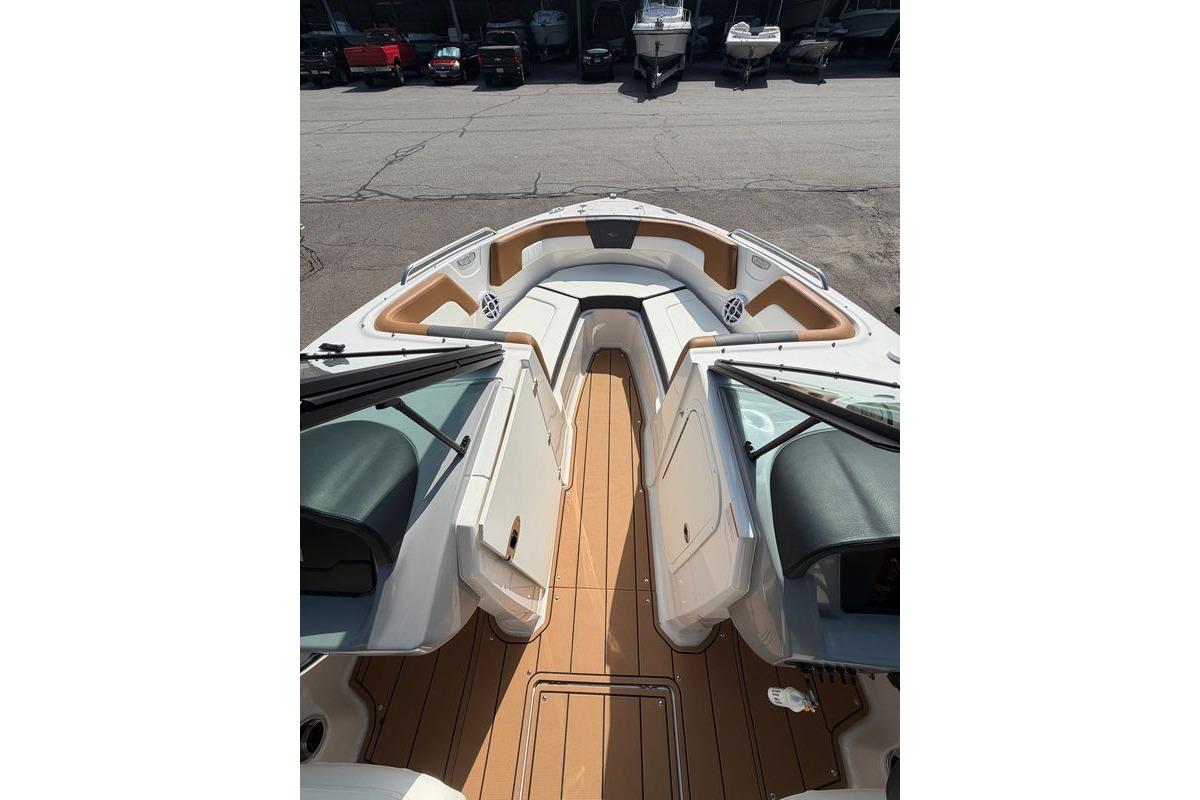 2025 Chaparral 230 SSi boat interior with tan seating and wood-style flooring.