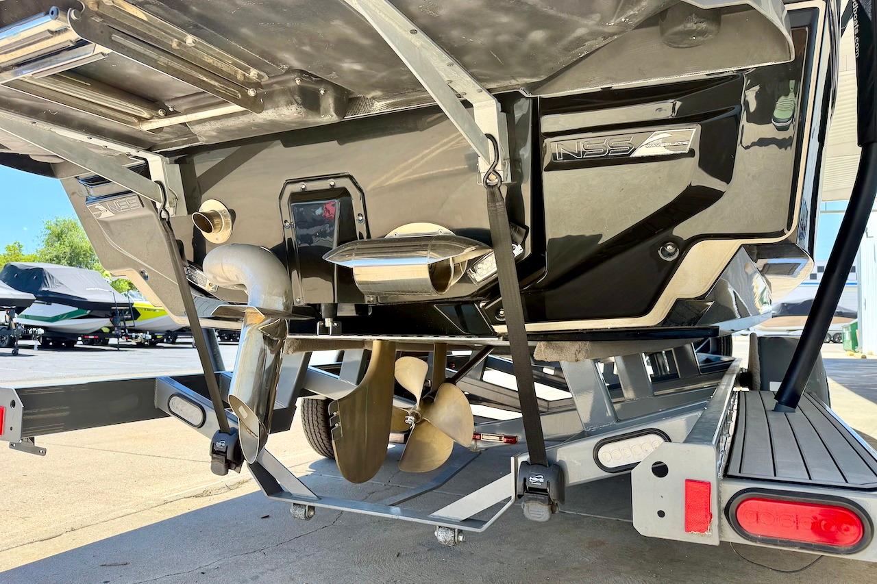 2021 Nautique Super Air Nautique G23 boat on trailer, showcasing propeller and exhaust system.