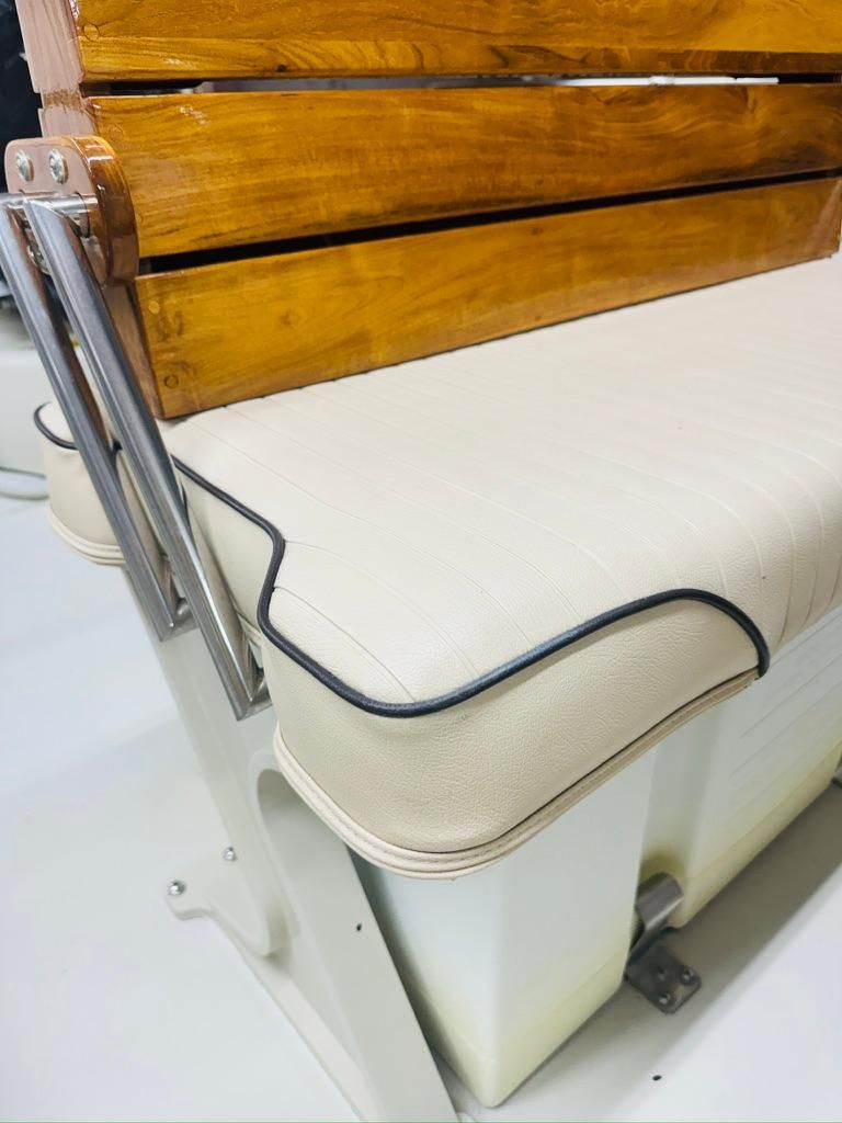 A cream-colored bench seat with a wooden backrest and metal brackets.