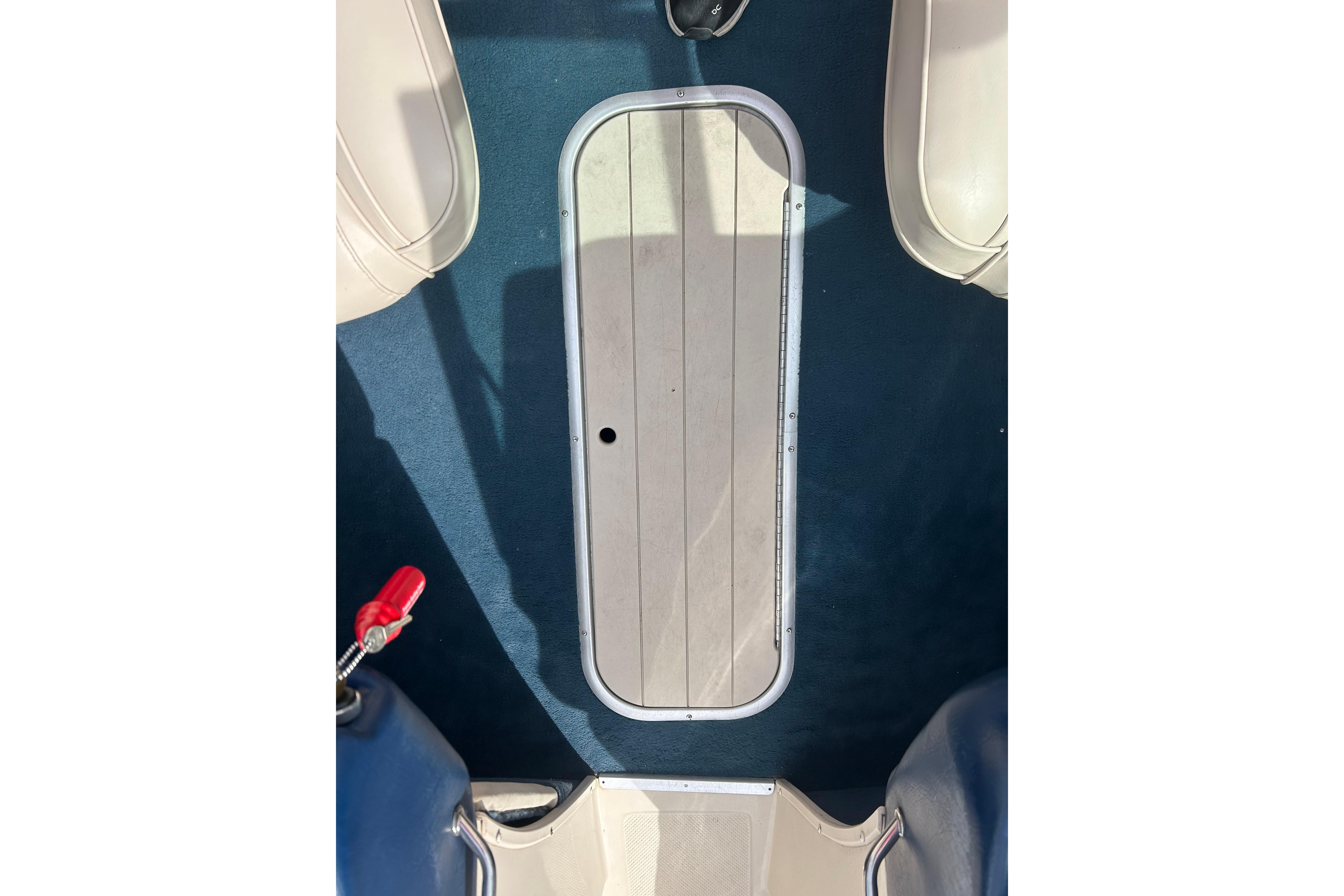 Interior view of a 1996 Mariah 180 Shabah boat, featuring a blue carpeted floor.