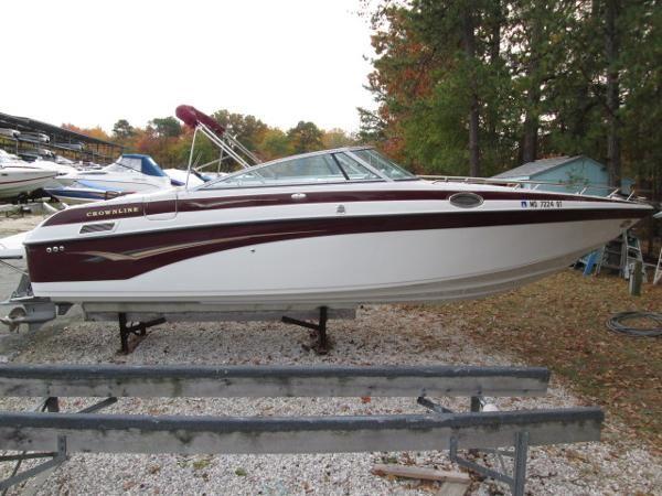 2004 Crownline 288 BR boat on trailer, parked outdoors with trees in background.