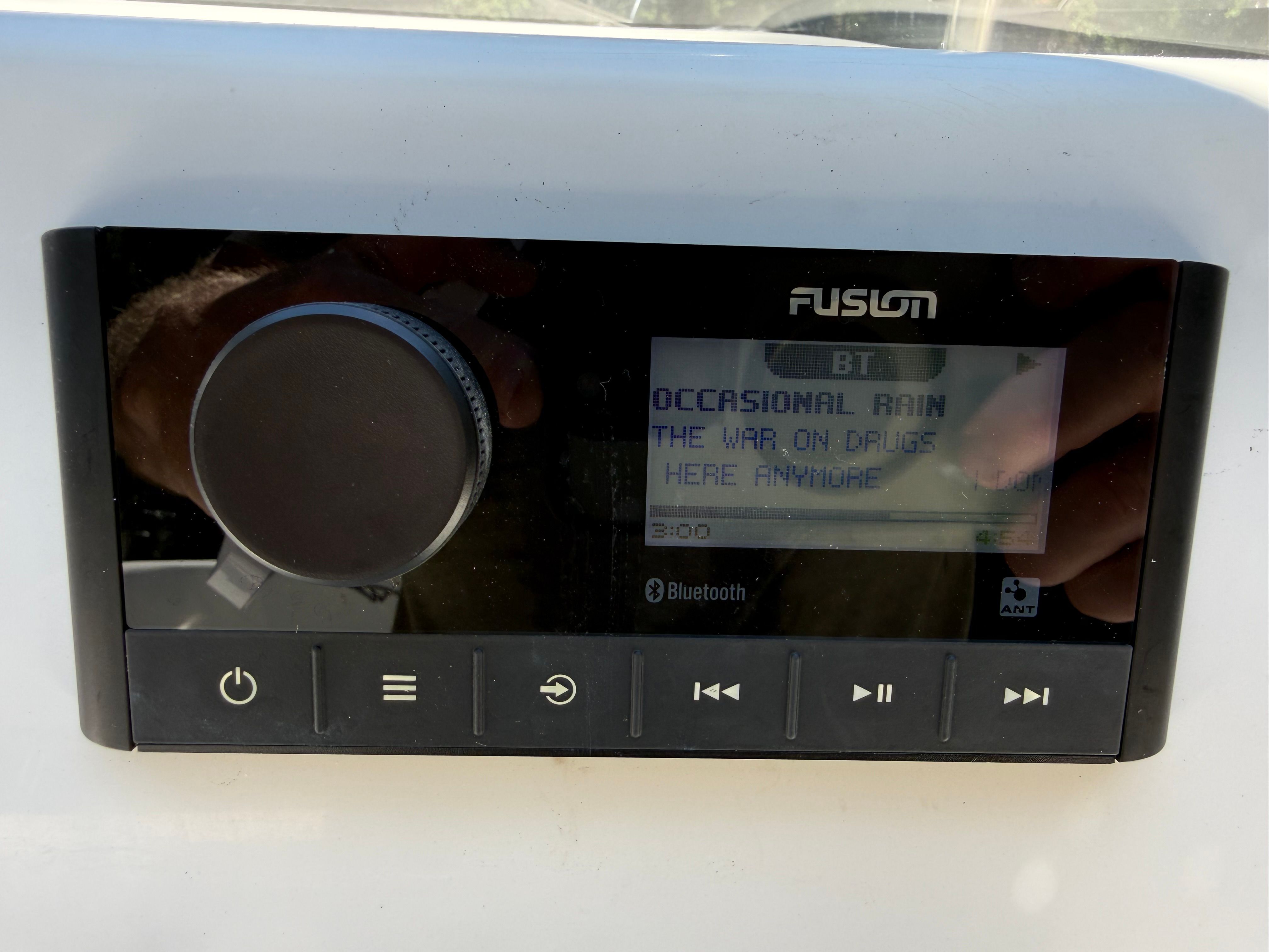 A Fusion marine stereo with Bluetooth displays "Occasional Rain" by "The War on Drugs."