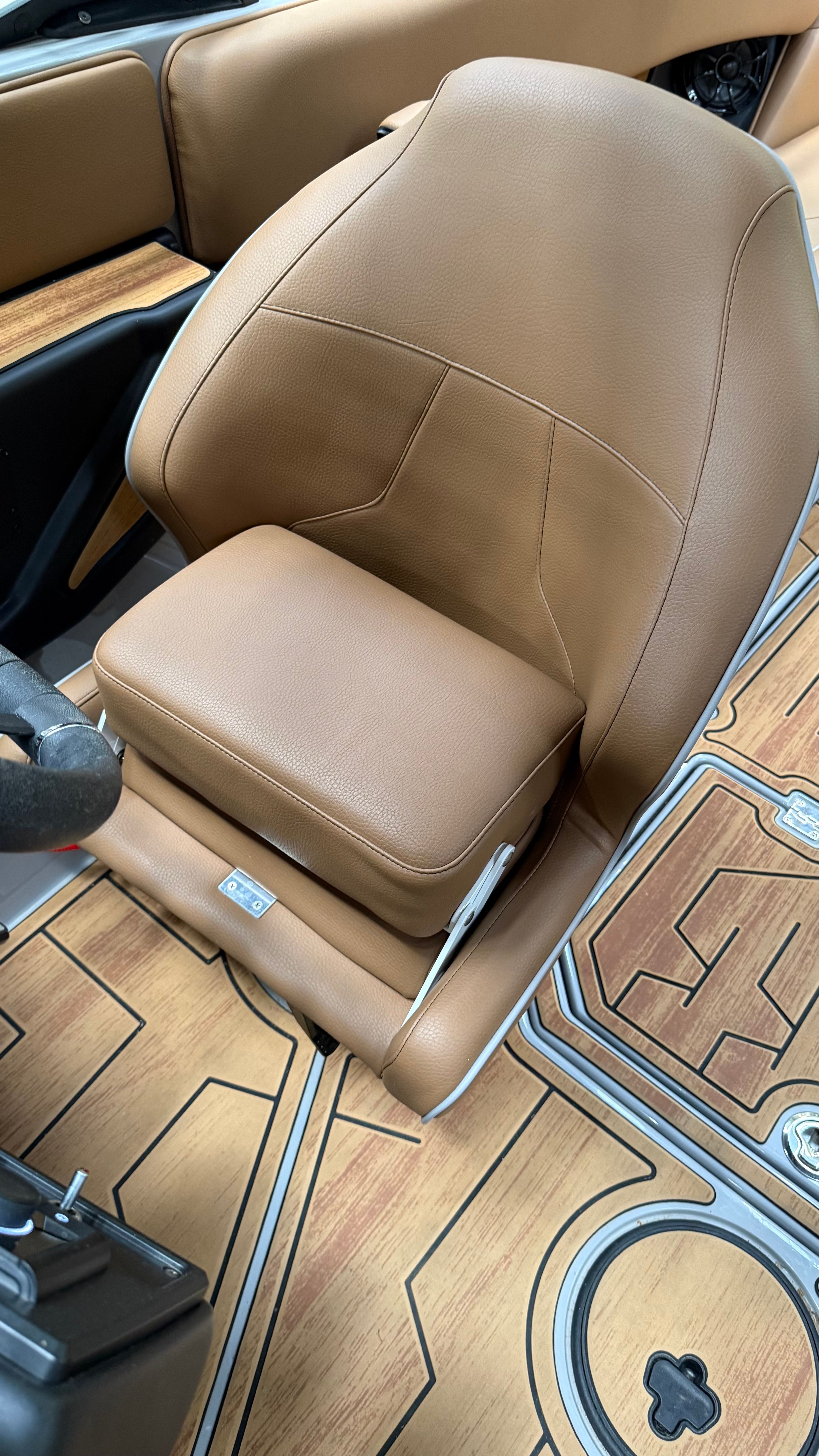 The interior of a 2025 Malibu Mojo with a brown leather seat and wood flooring.