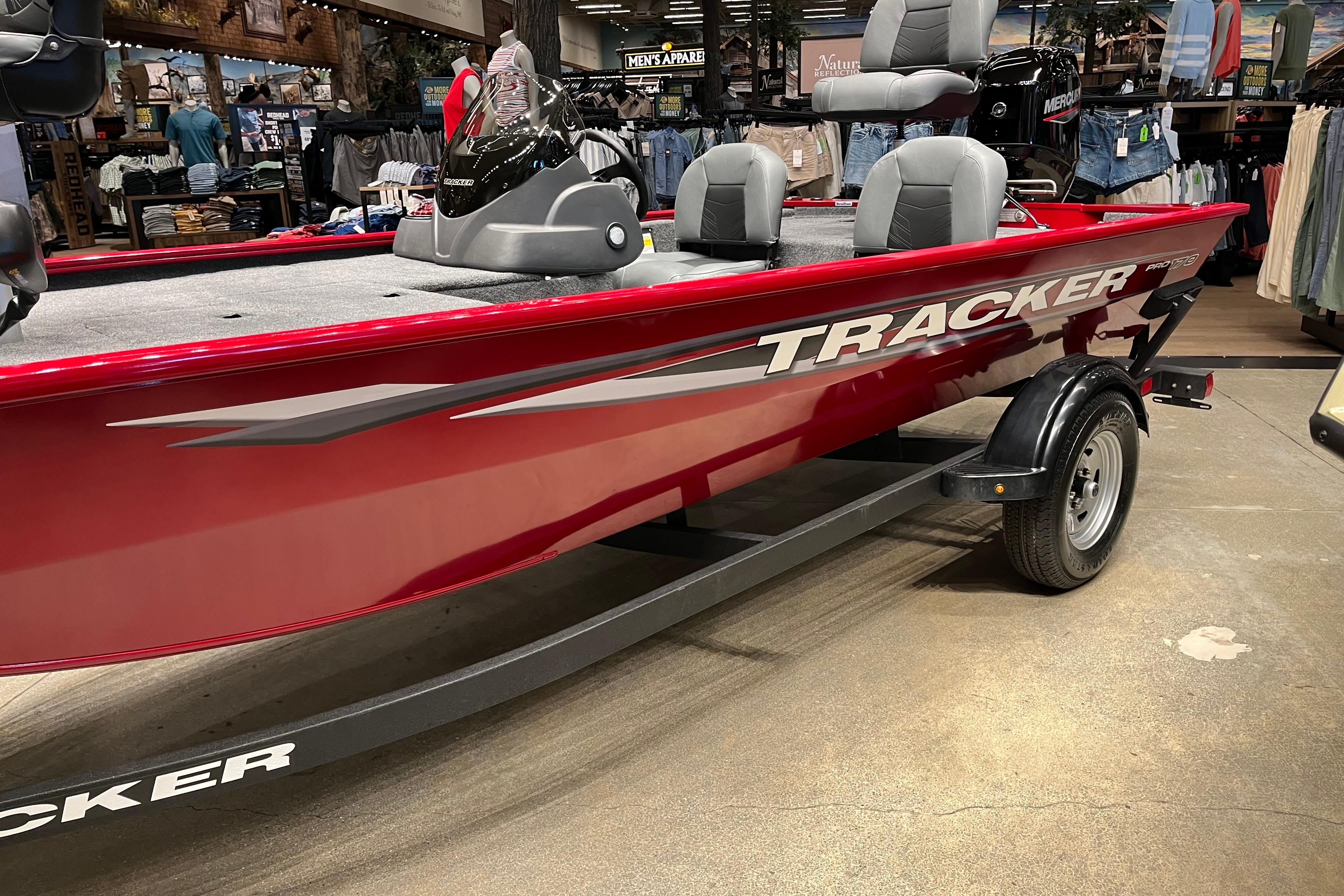 2026 Tracker Pro 170 boat displayed indoors, featuring sleek red design and comfortable seating.