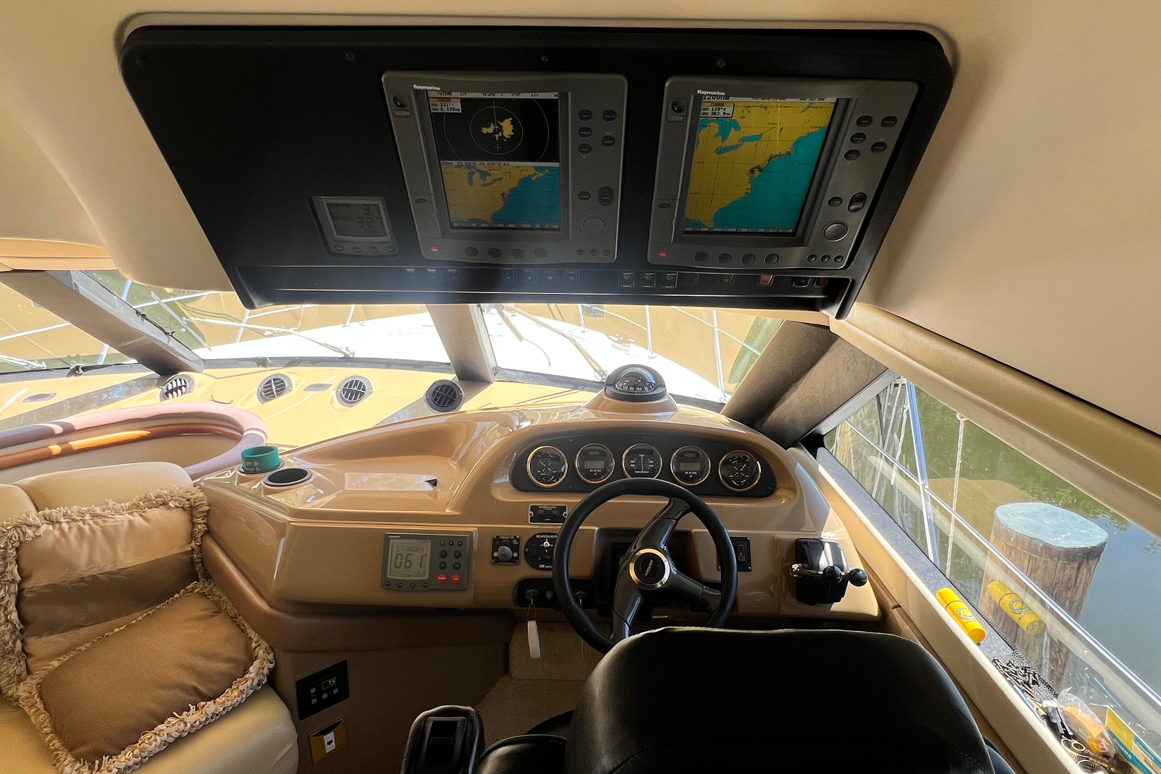 Interior view of 2003 Carver 450 Voyager Pilothouse helm with navigation screens.