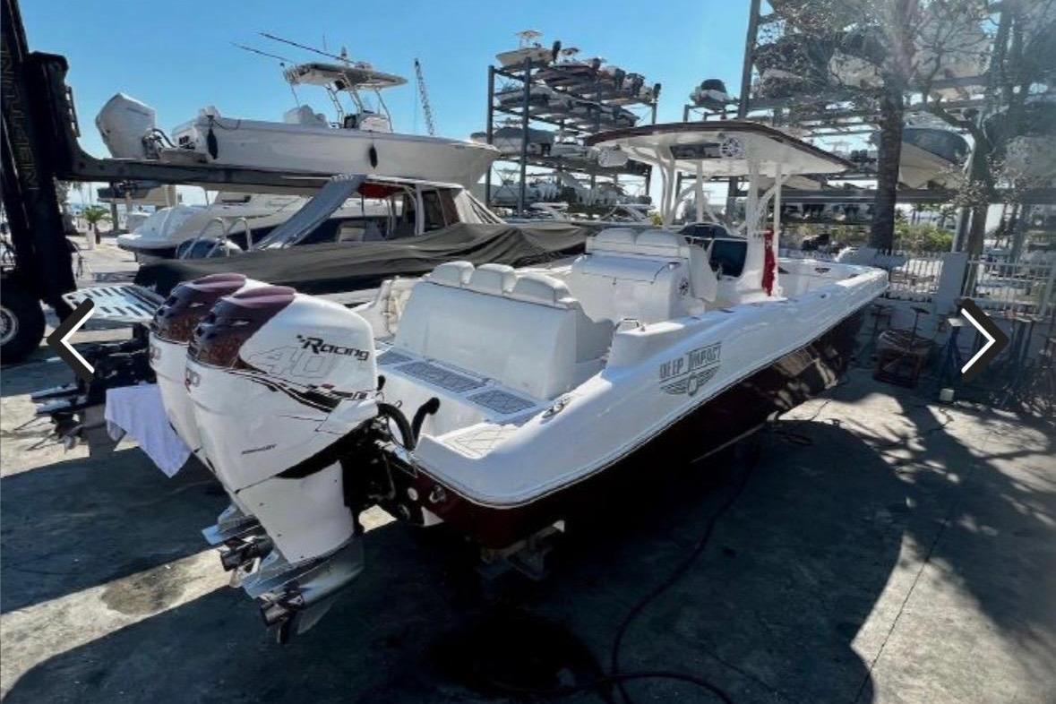 2015 Deep Impact 33 boat with twin outboard engines in a marina setting.