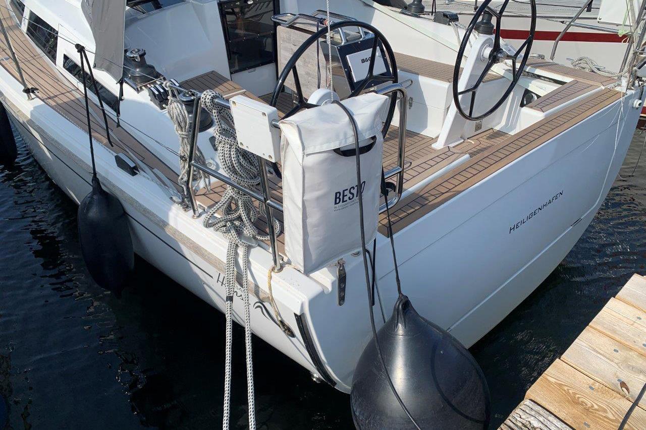 2022 Hanse 348 sailboat docked, featuring dual steering wheels and deck equipment.
