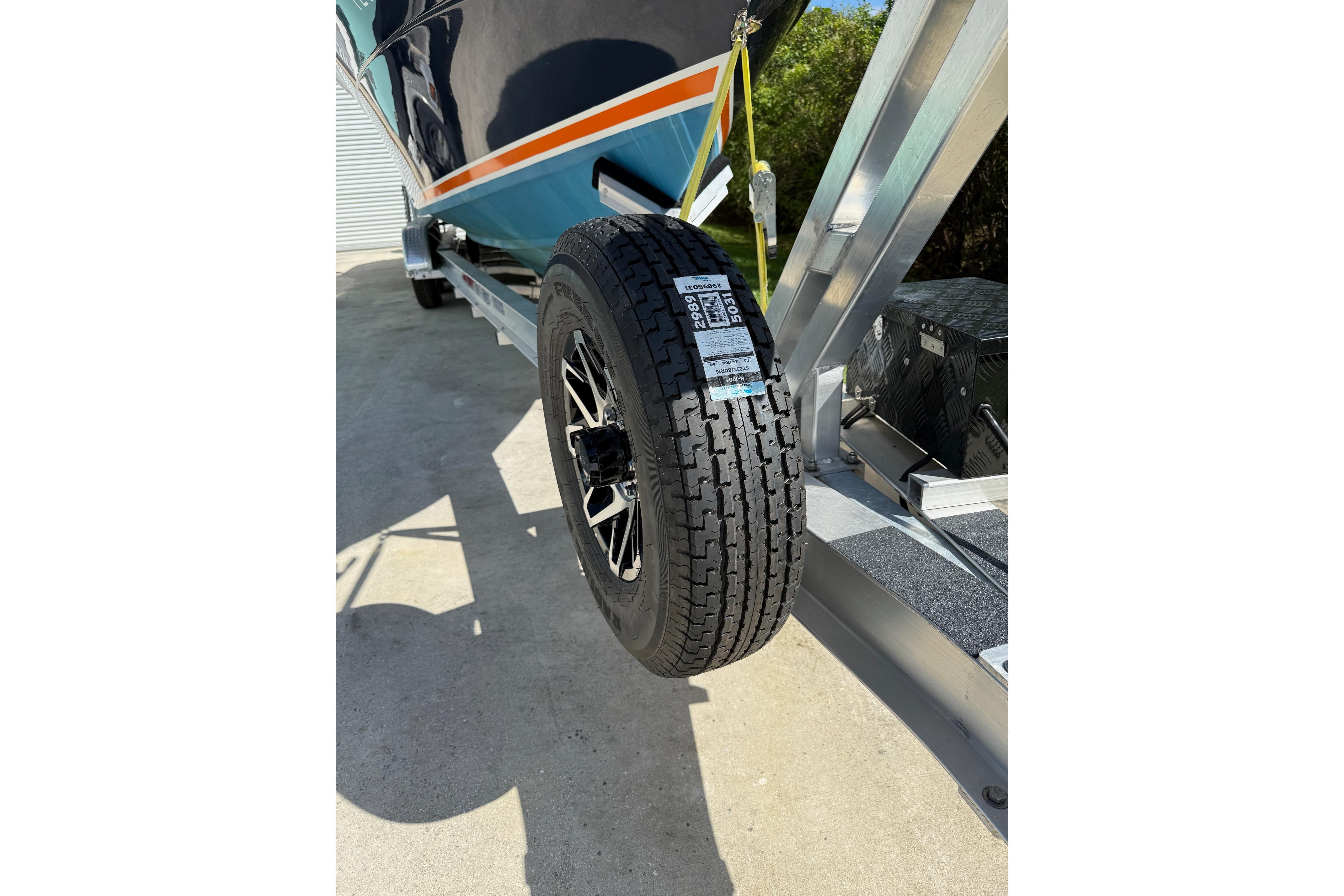 2001 Marlago 35 Cuddy boat on trailer, close-up of tire and hull.