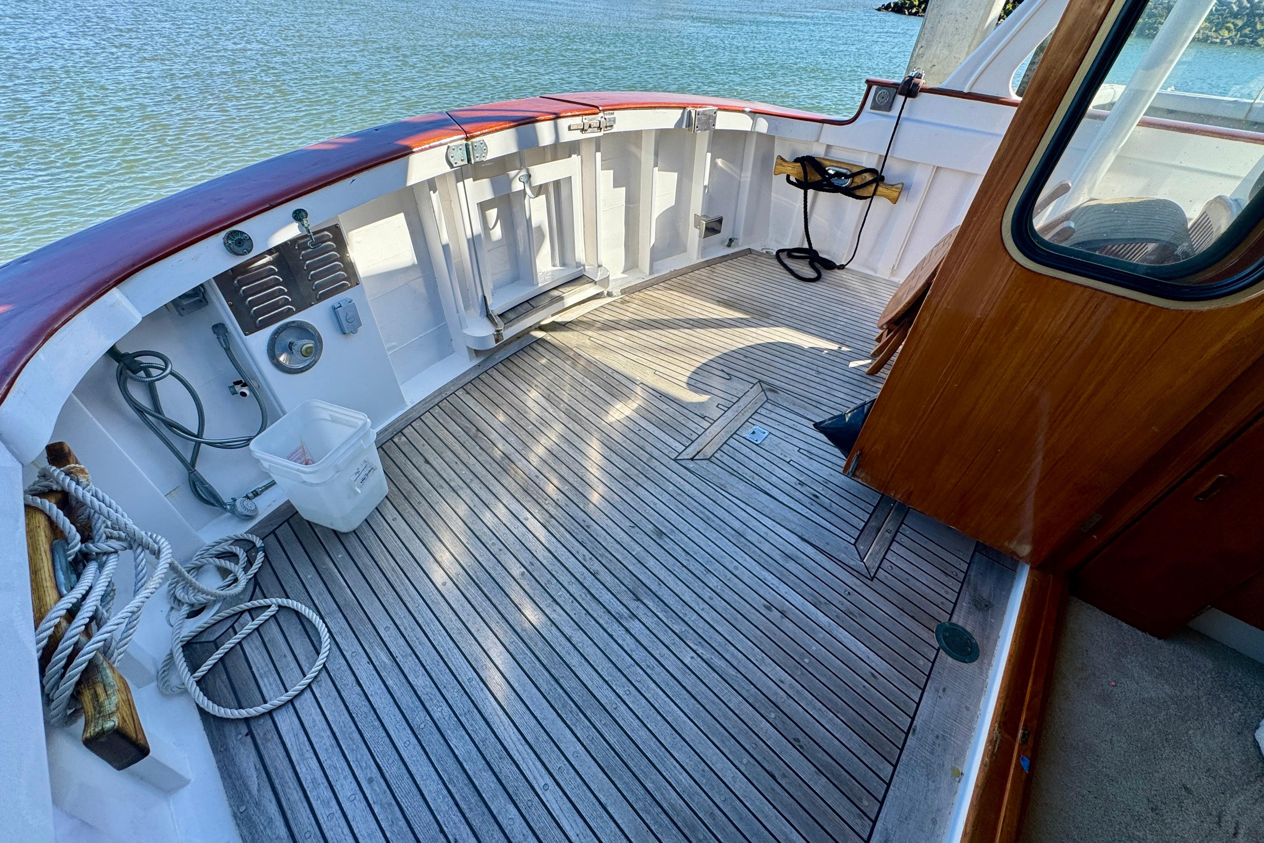 1958 Blanchard Pilothouse boat deck with wooden flooring and nautical equipment.