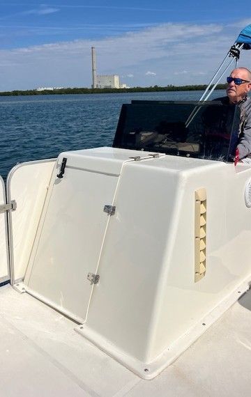 A man navigates a Beachcat catamaran on calm waters.