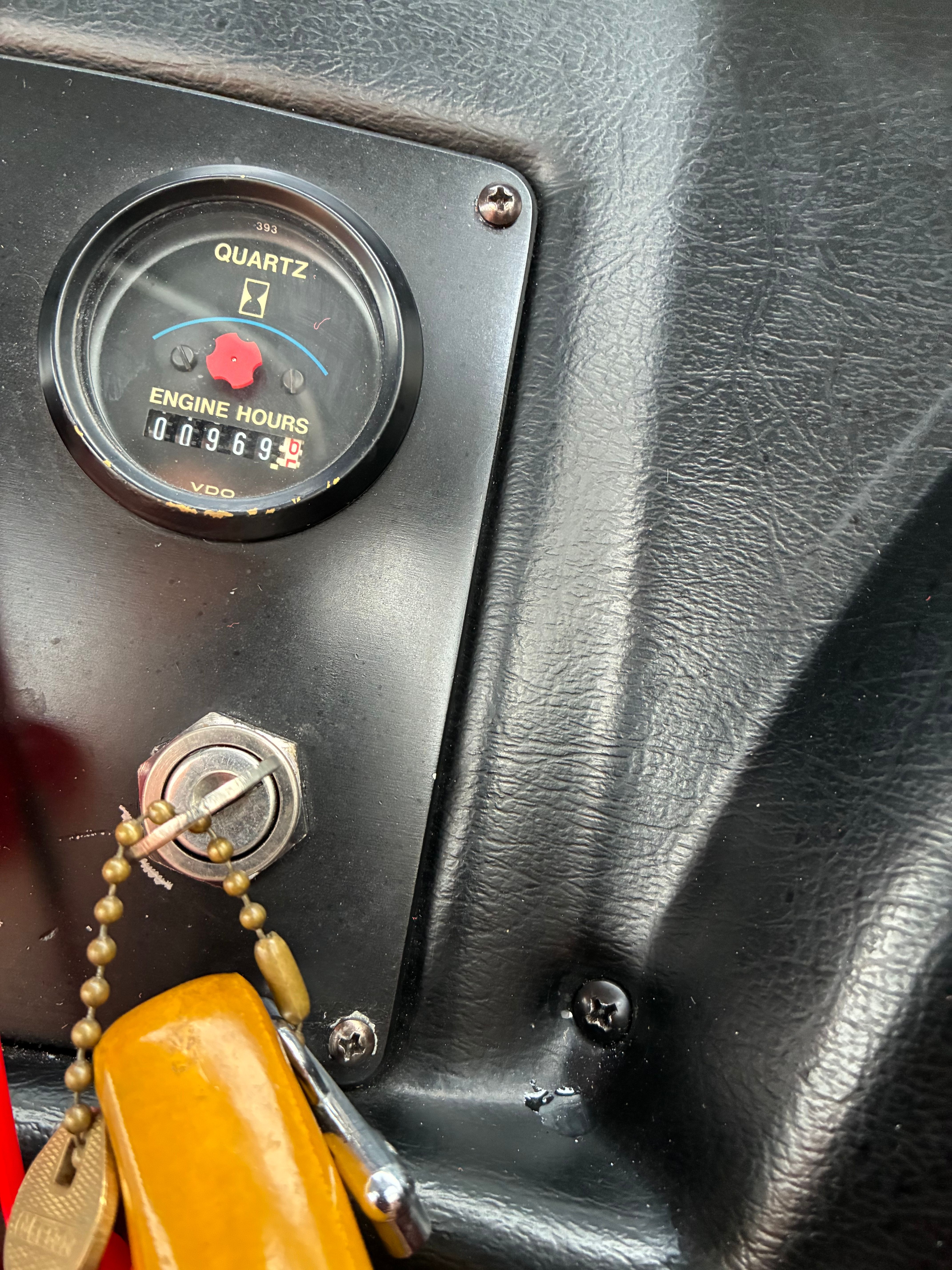 Close-up of an engine hour meter and ignition switch on a boat.