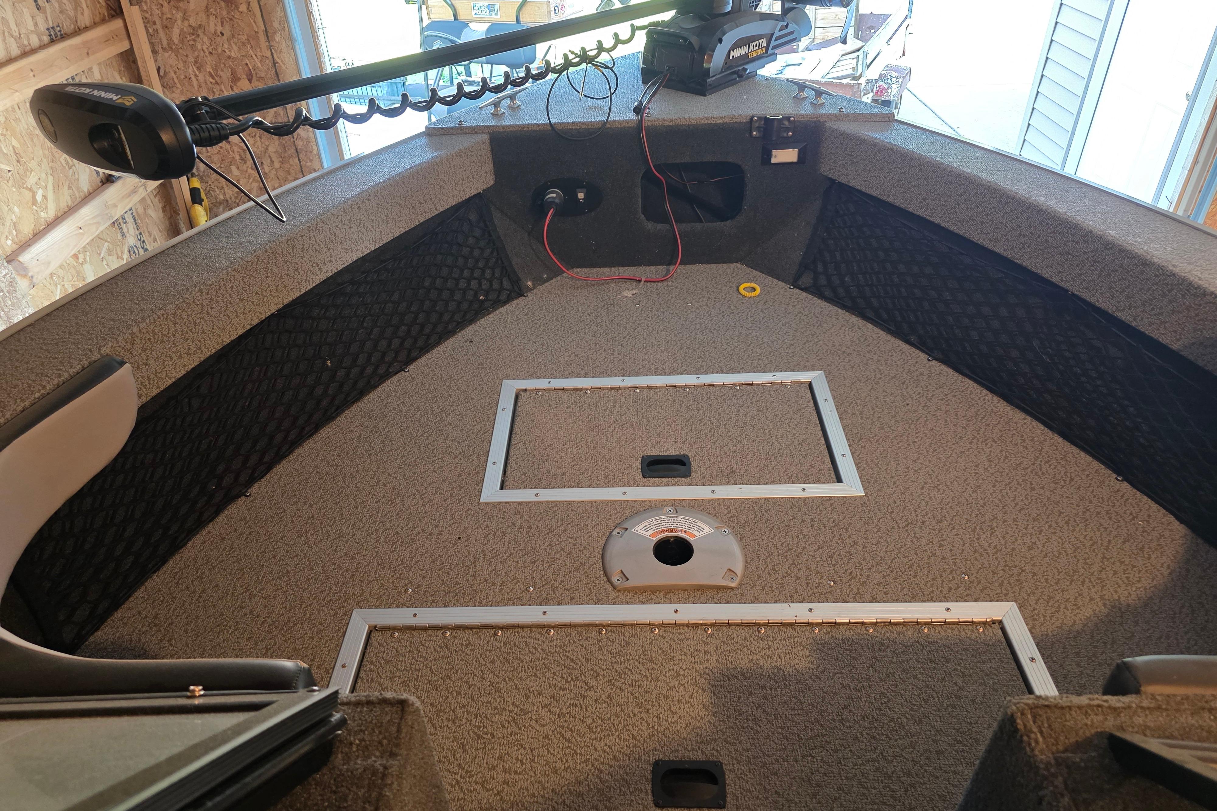 Interior of a 2022 Starweld Fusion Pro 20 DC boat with carpeted deck and storage compartments.