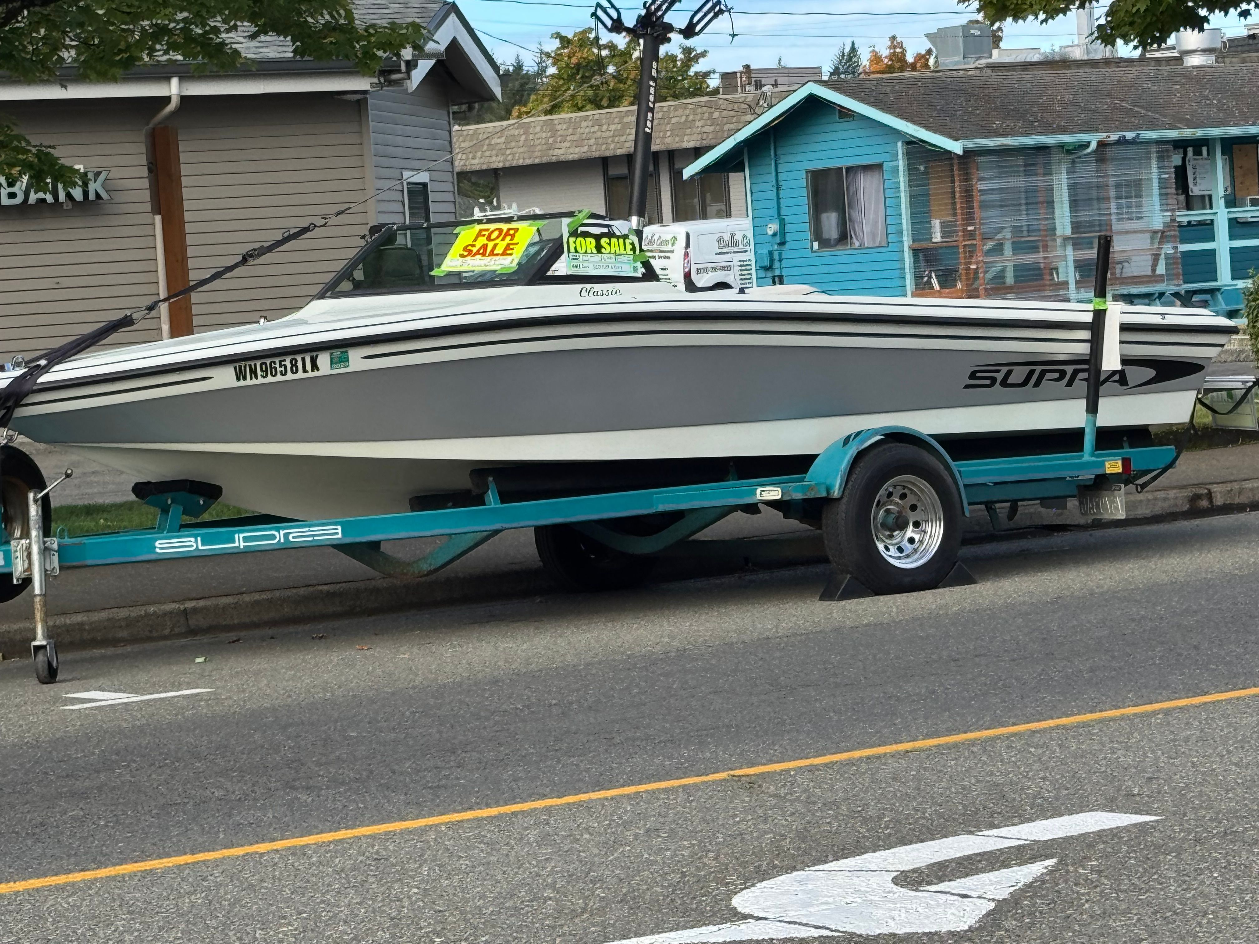 1990 Supra TS6M boat on trailer parked for sale.