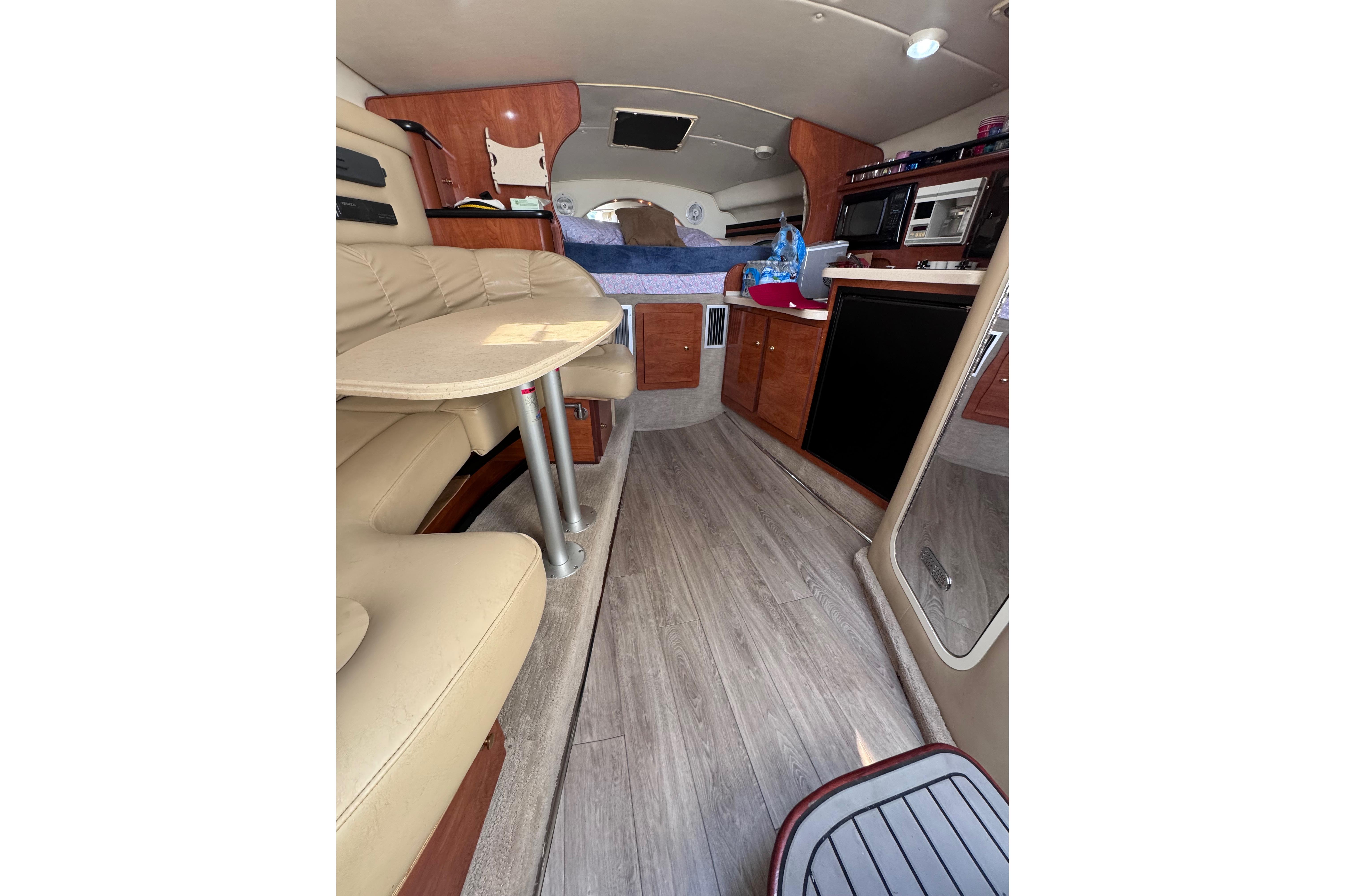 Interior of 2003 Rinker Fiesta Vee 312 boat with seating and kitchenette.