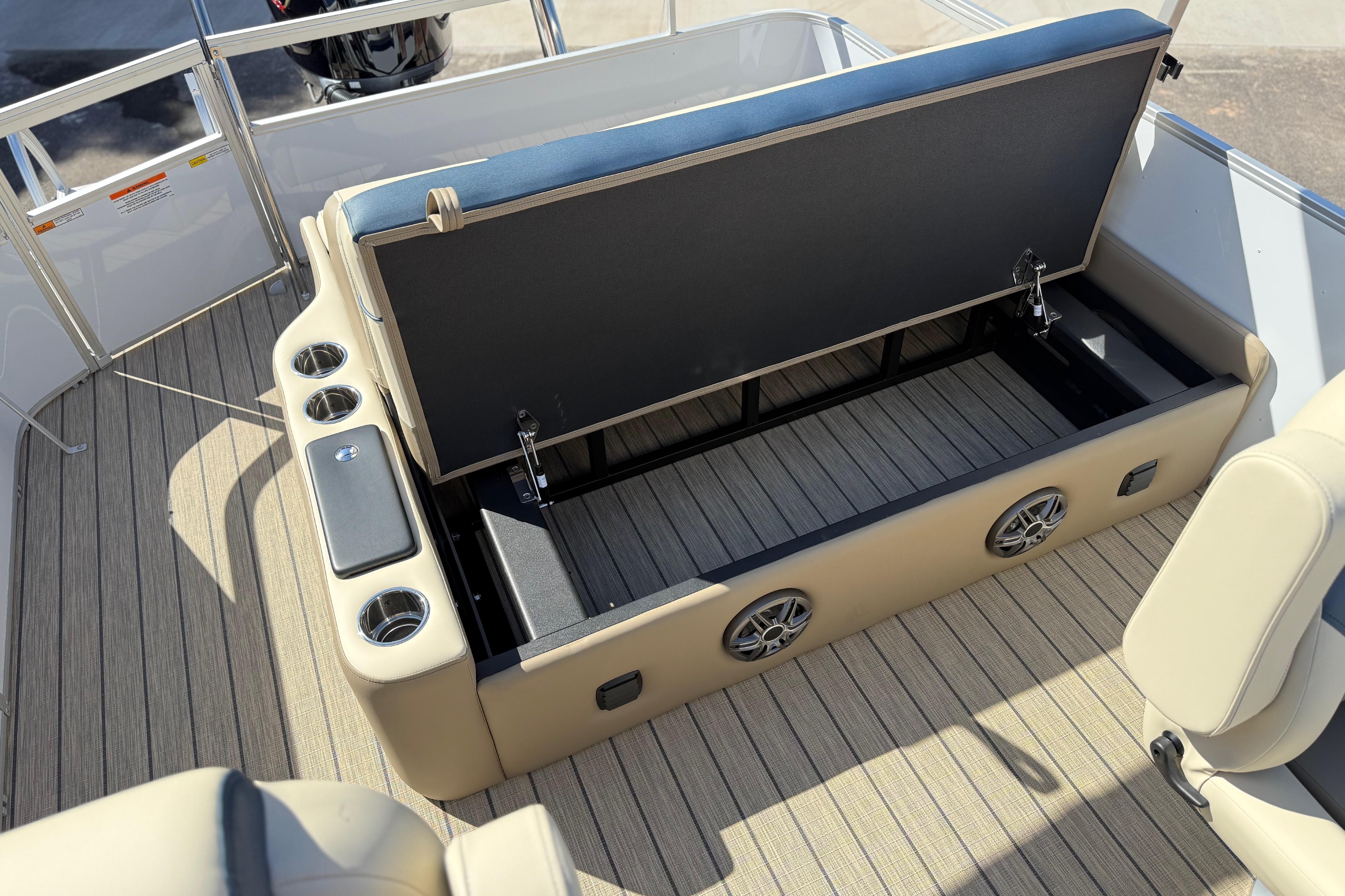 Open storage compartment on 2026 SunCatcher Select 322SL pontoon boat with cup holders and speakers.