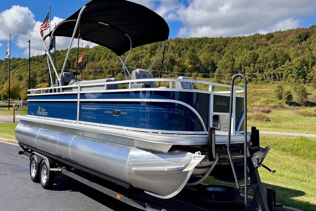 2026 Sun Tracker Sportfish 24 XP3 pontoon boat on trailer, scenic background.