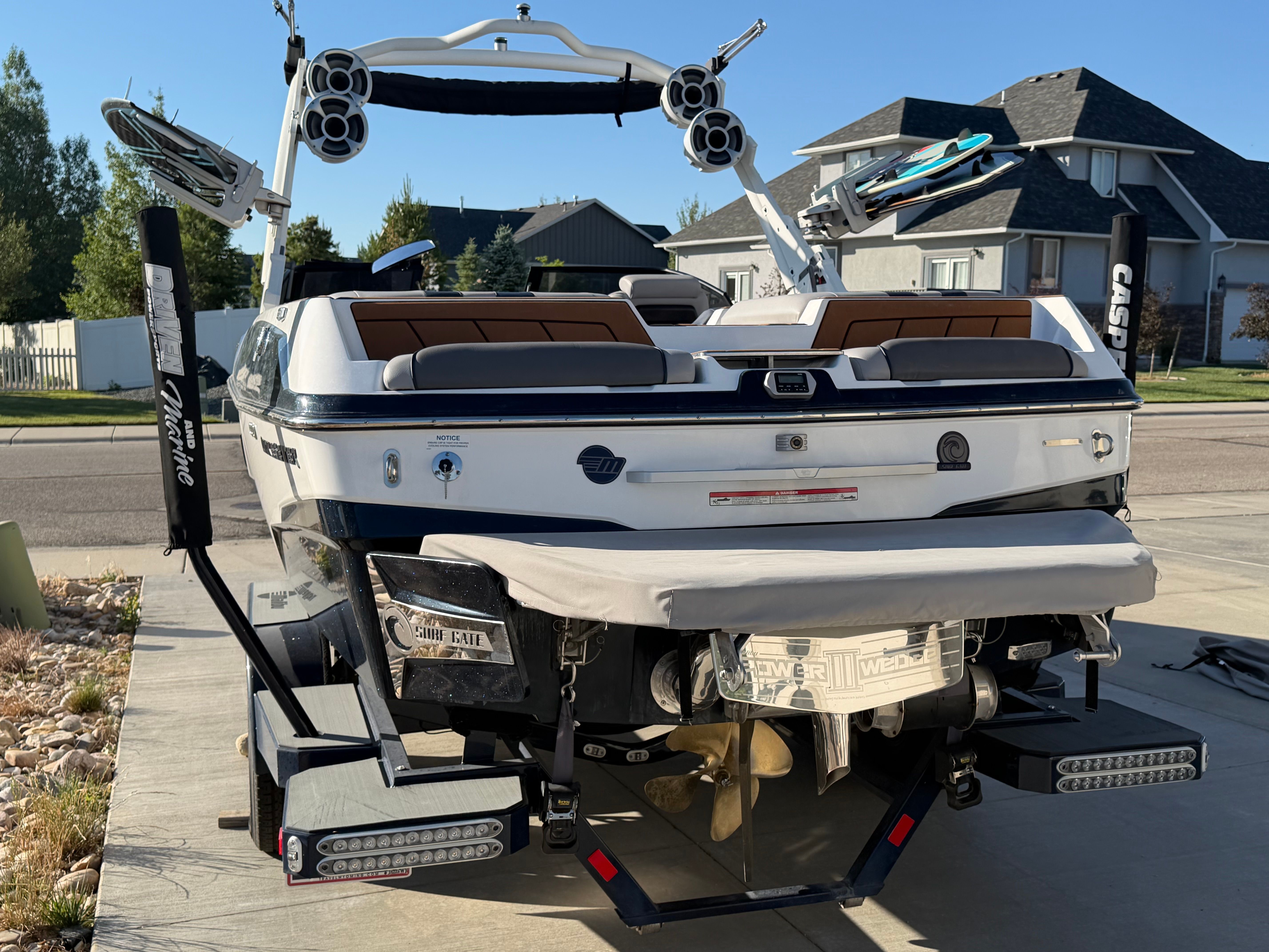 Rear view of a 2021 Malibu Wakesetter 23 LSV parked on a driveway with houses in the background.