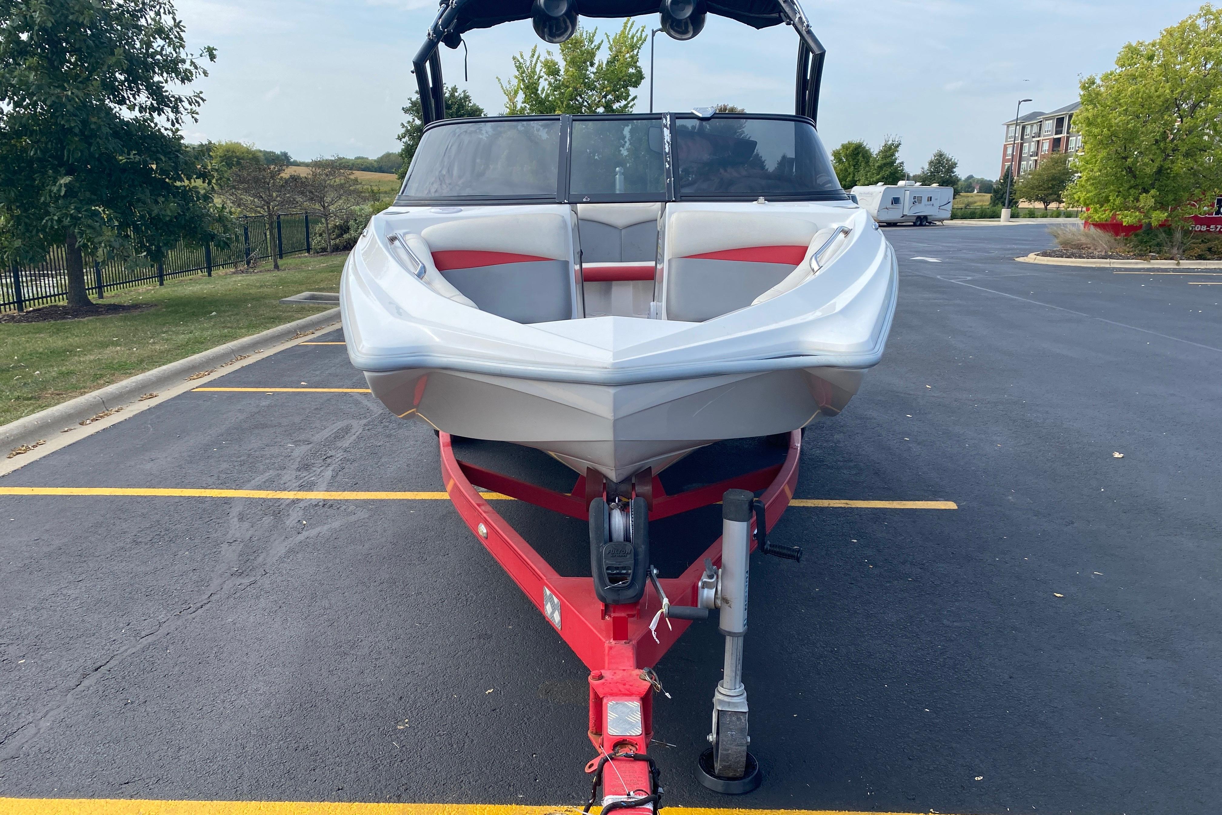 2014 Tigé R20 boat on red trailer in parking lot.