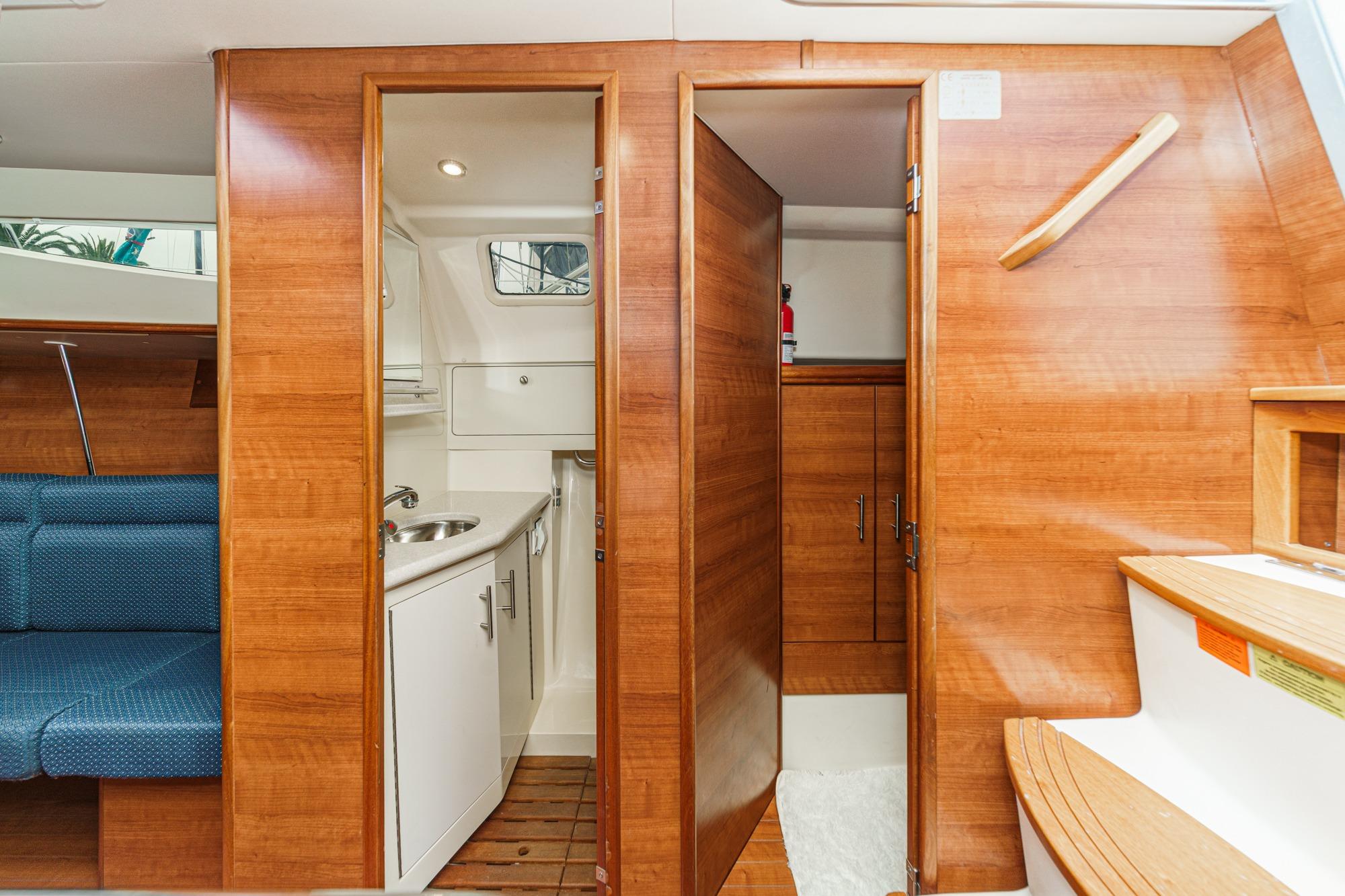 Interior of 2015 Hunter 33 sailboat featuring wooden cabinetry and compact bathroom.
